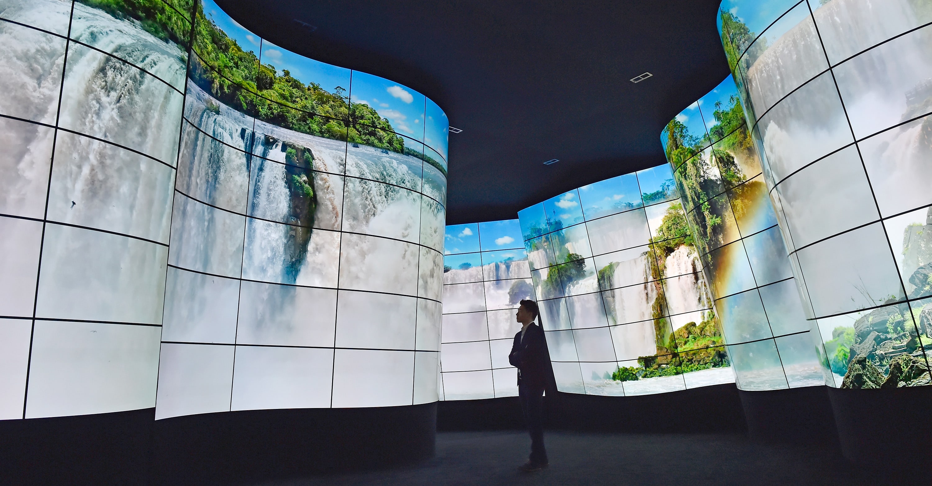 An attendee walks through LG's television display at CES 2018