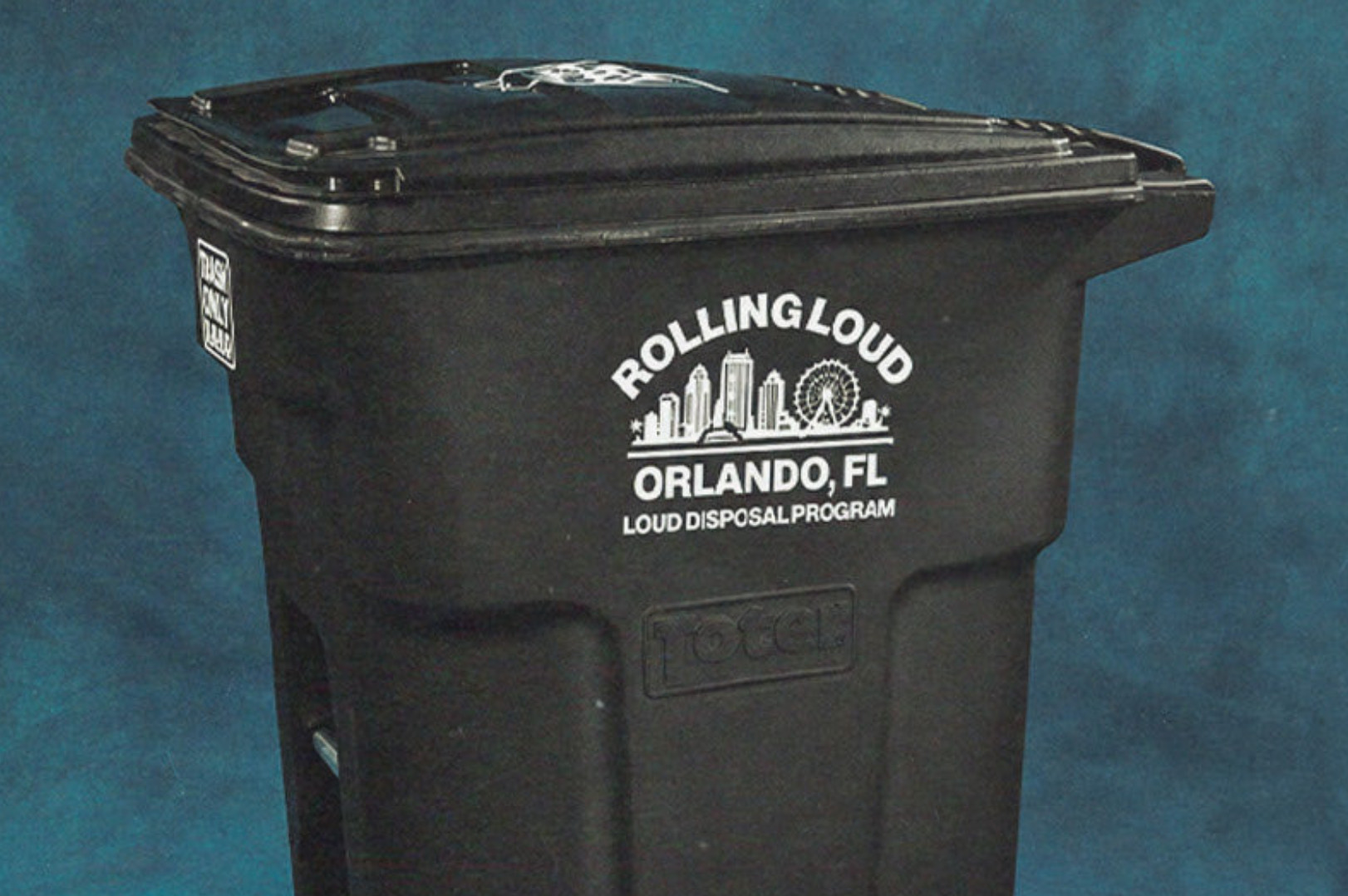 A black trash bin with "Rolling Loud Orlando, FL Loud Disposal Program" printed on it, set against a blue background.
