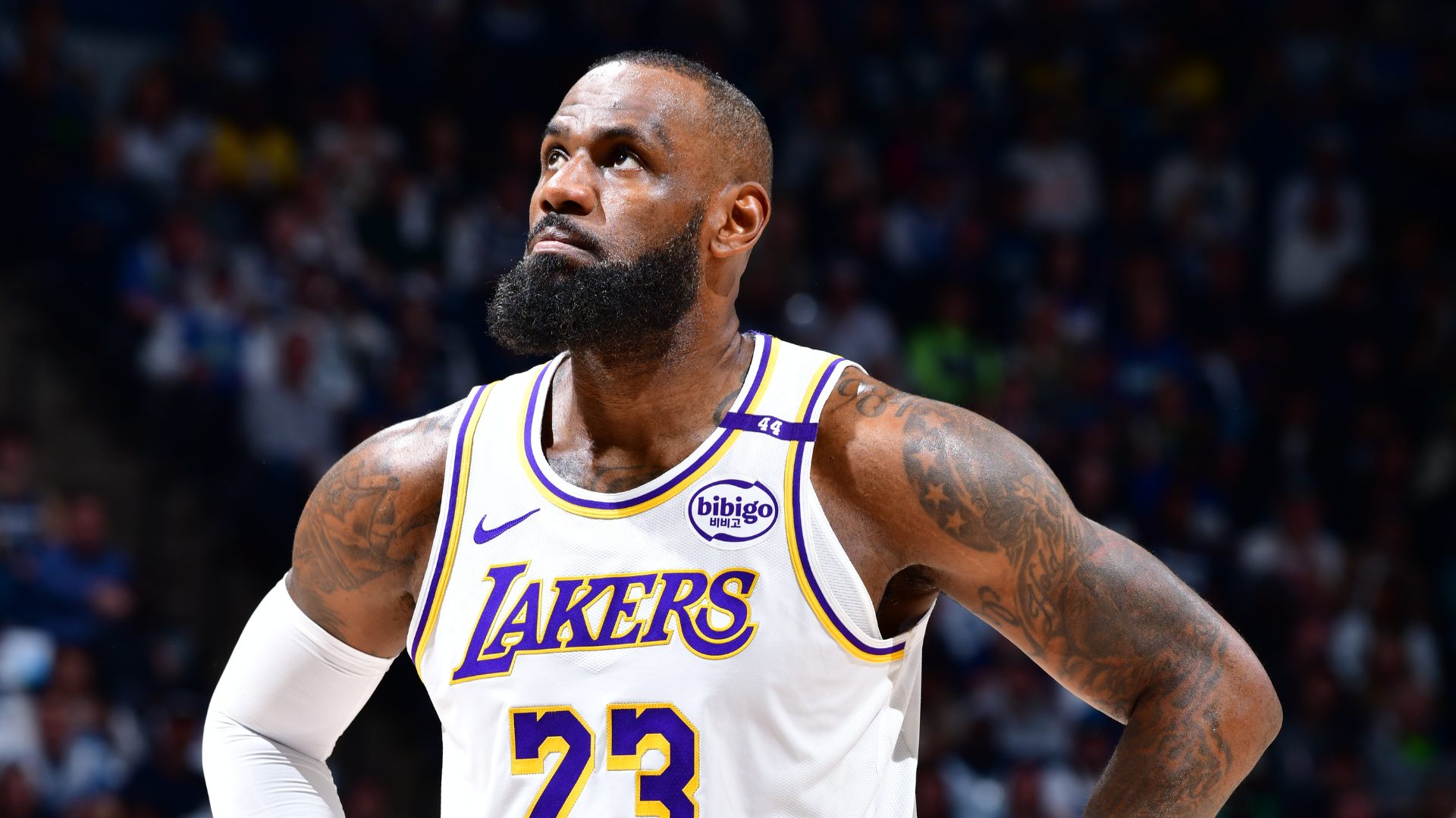 LeBron James, wearing a Los Angeles Lakers jersey, looks upward with a focused expression during a basketball game.