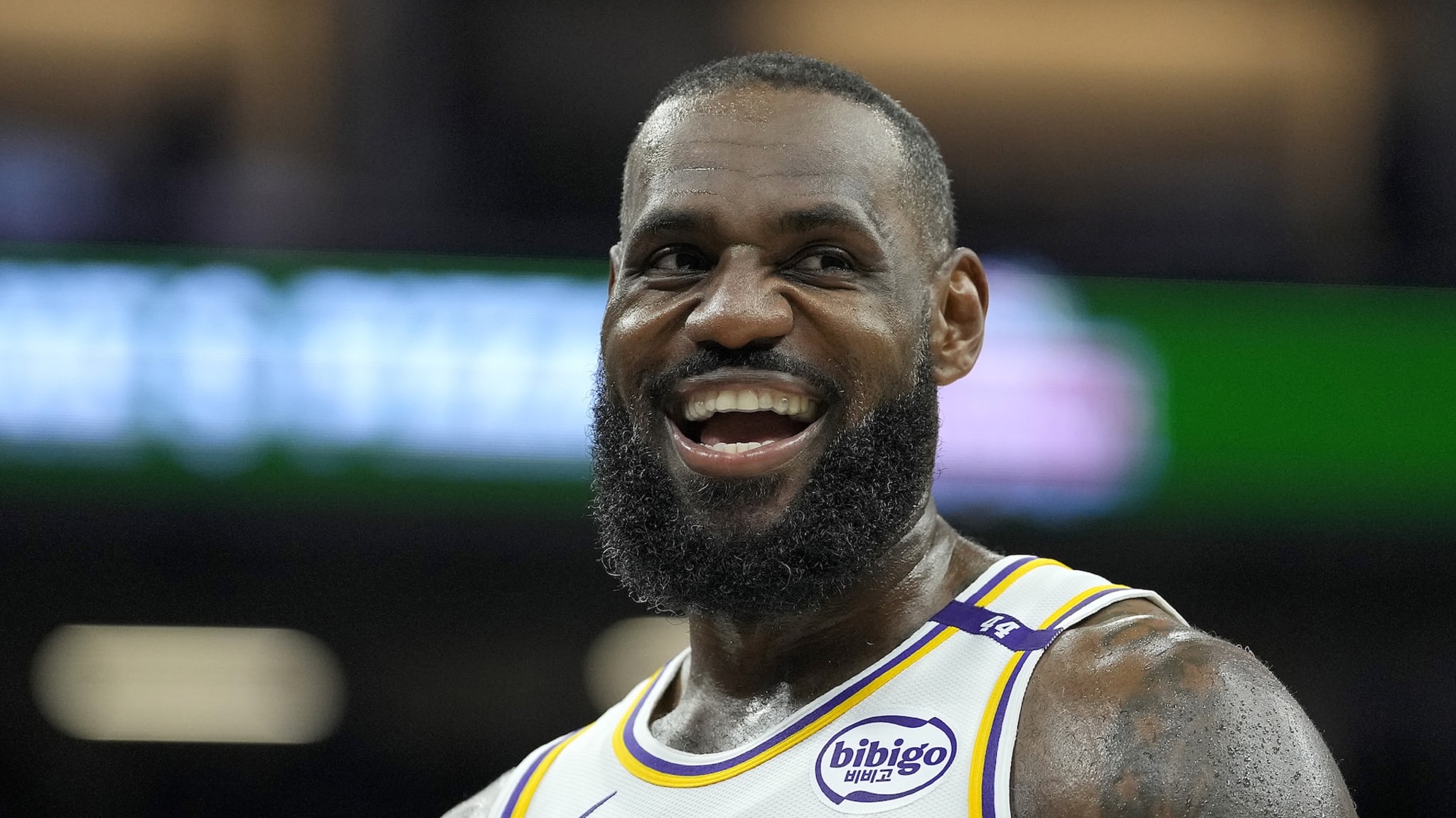 LeBron James looks on smiling, while on the court.