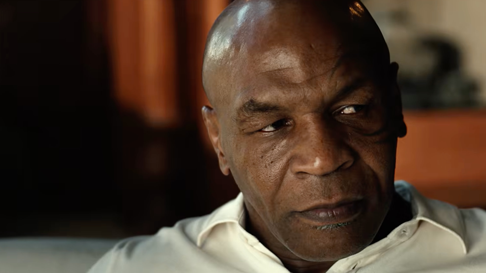 Mike Tyson, wearing a white shirt, looking contemplative.