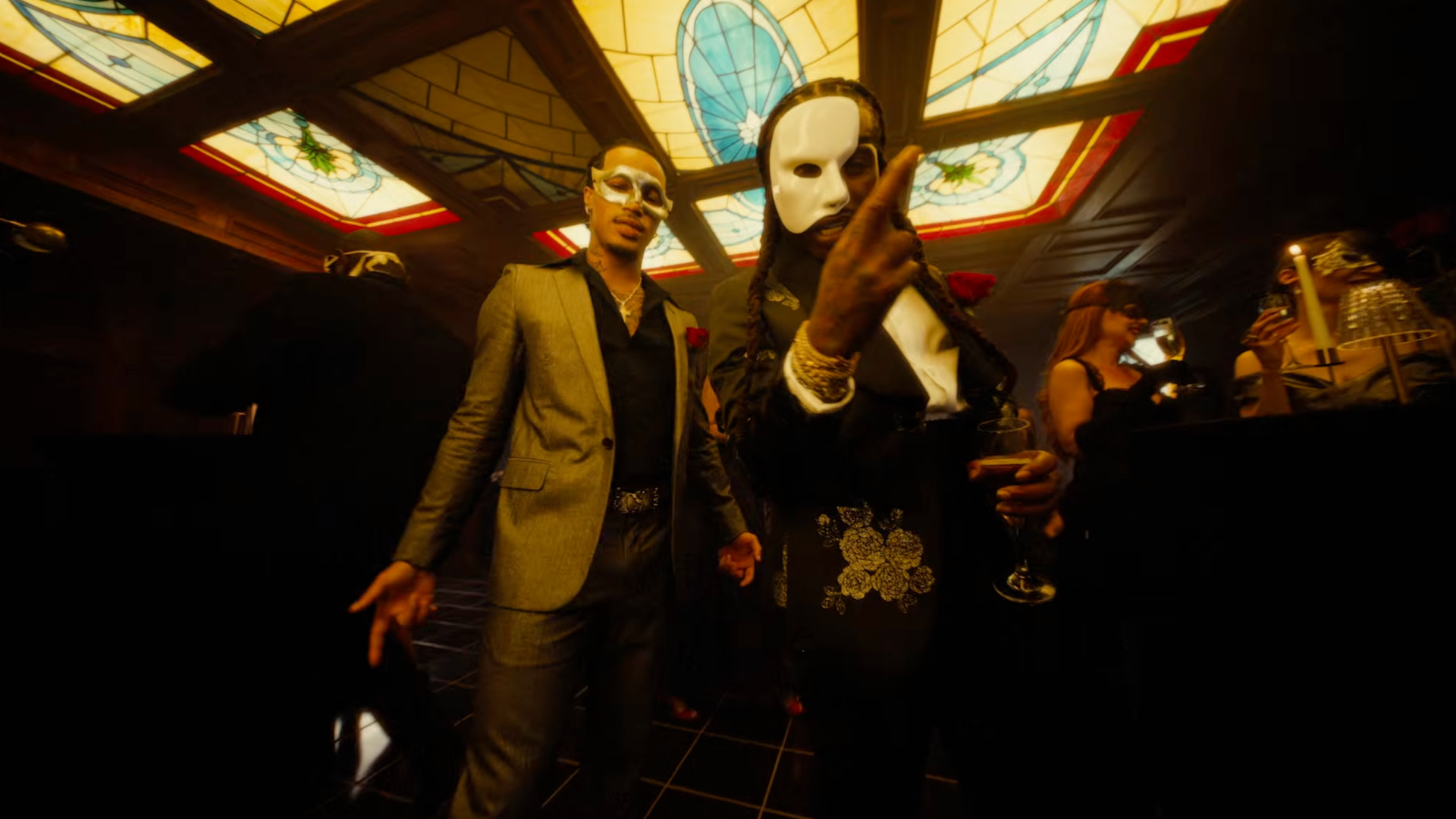 PlaqueBoyMax and Jacquees wearing white masks at a formal event, under a stained glass ceiling.