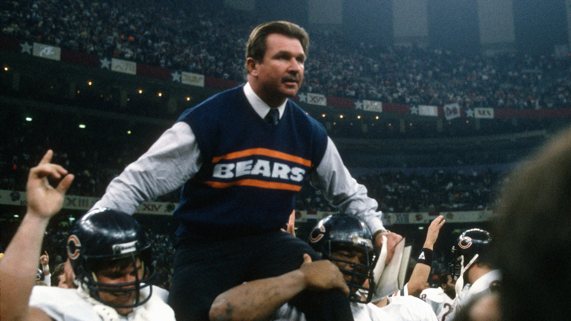 Mike Ditka is being carried by Chicago Bears players in a stadium, celebrating a victory.