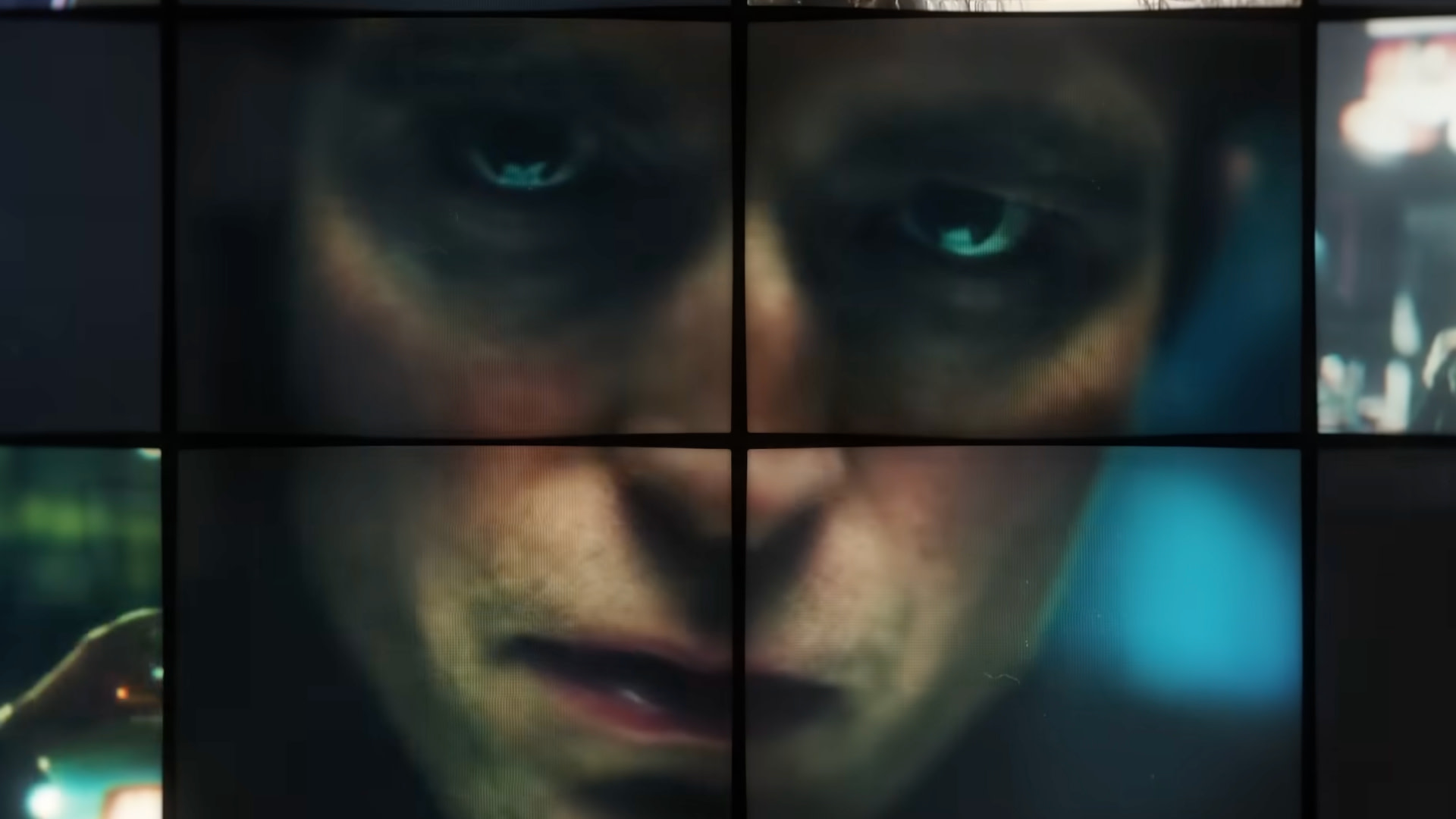 A close-up of a Robert Pattinson's face split across multiple screens, creating a fragmented effect. The expression is intense and focused.