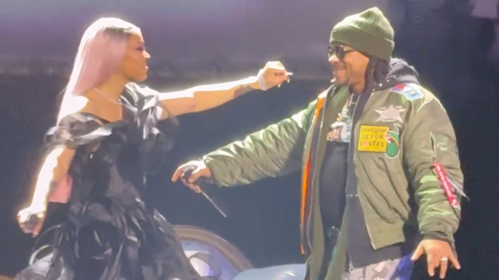 Monica in a black dress playfully interacts with Max B on stage