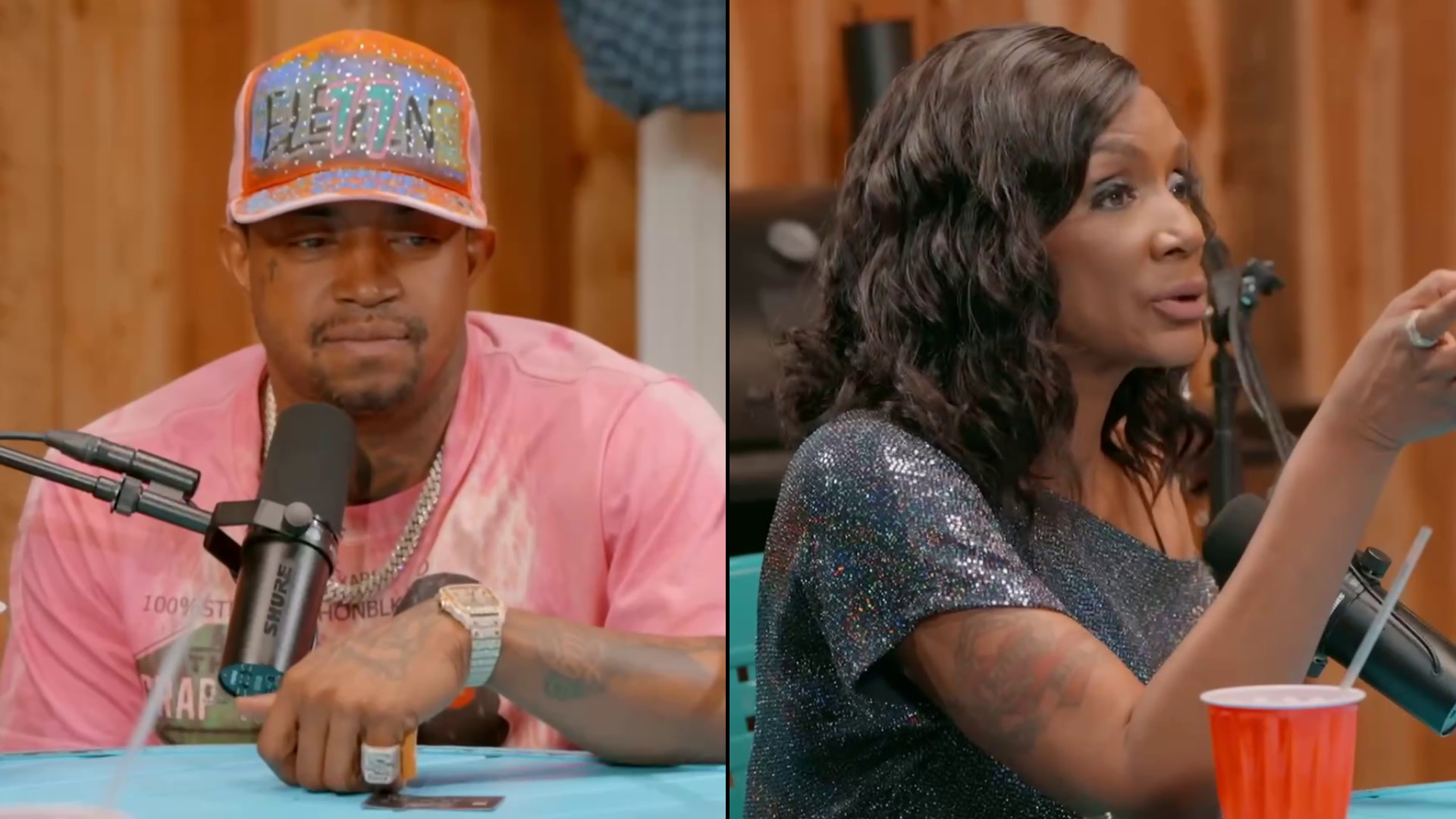 Two people are seated at a table with microphones. Lil Scrappy wears a colorful cap and pink shirt; Momma Dee wears a sparkly top.