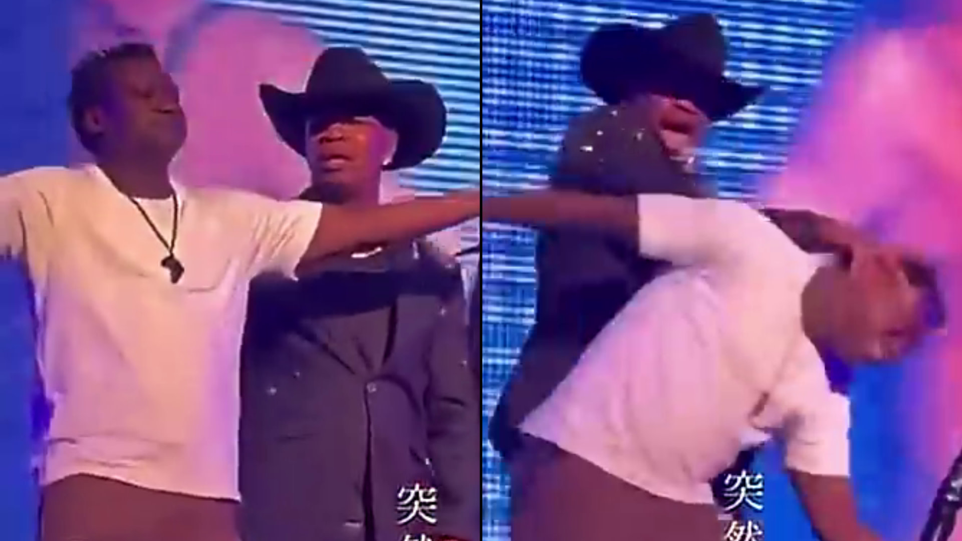 A man in a white shirt is playfully interacting with another man in a cowboy hat and dark jacket on stage with colorful lighting.