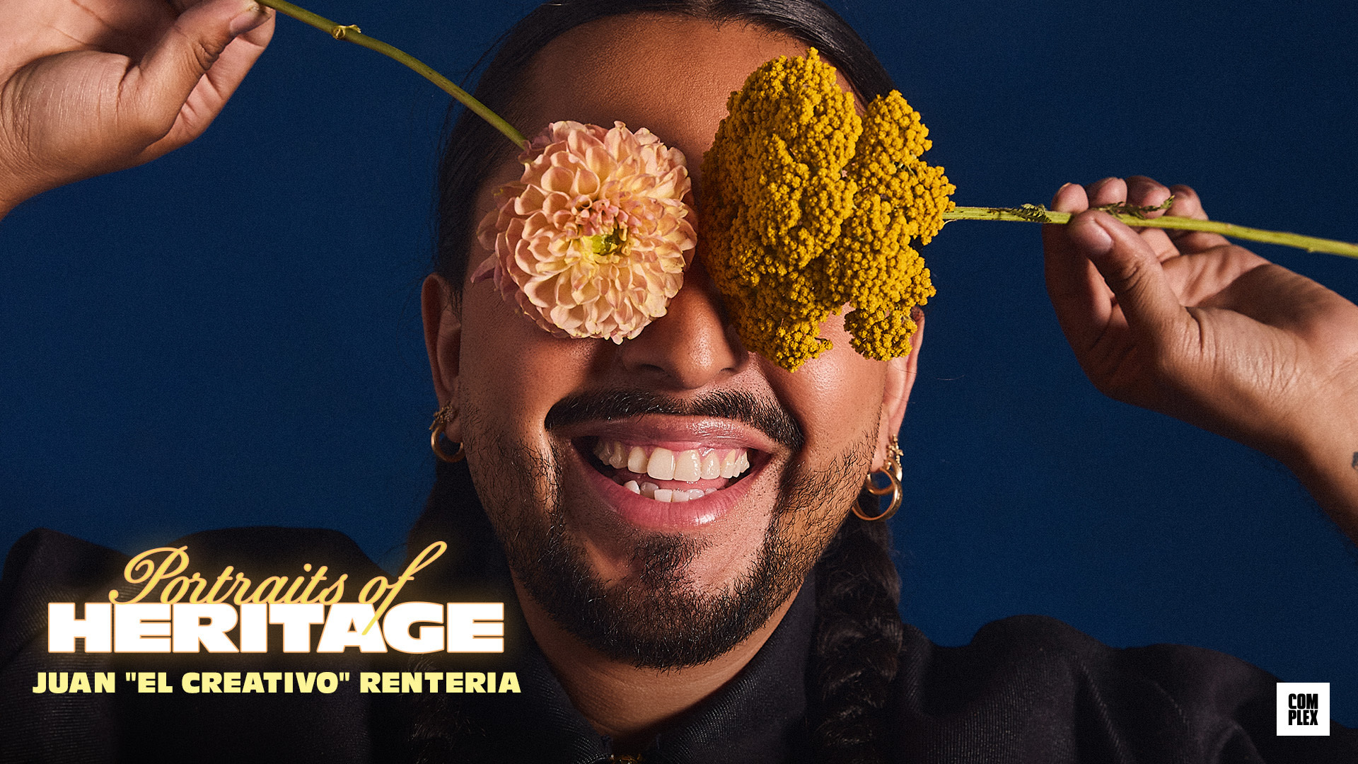 {"alt":"A person smiles while holding flowers over their eyes, with text reading 'Portraits of Heritage, Juan \"El Creativo\" Renteria.'"}