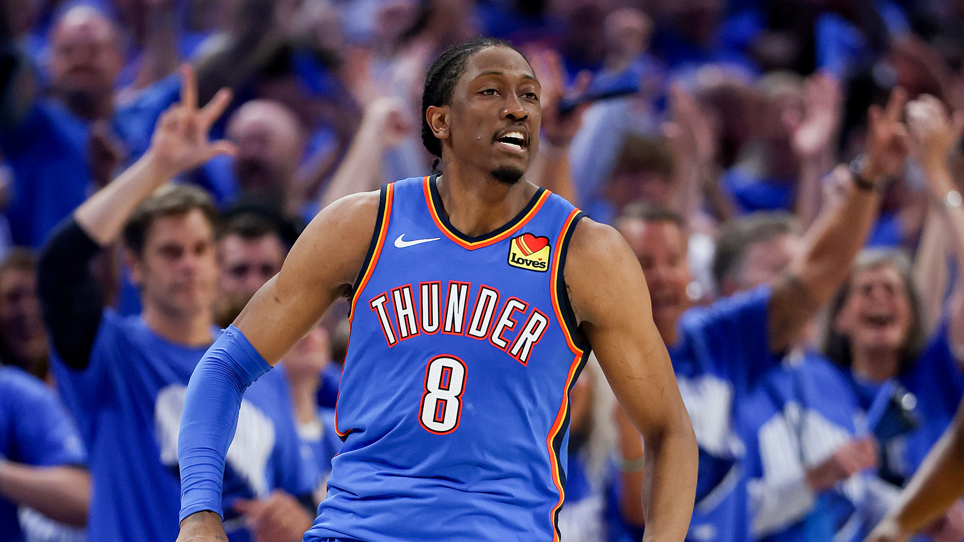 Jalen Williams in a blue Oklahoma City Thunder jersey, No. 8, on the court with cheering fans in the background.