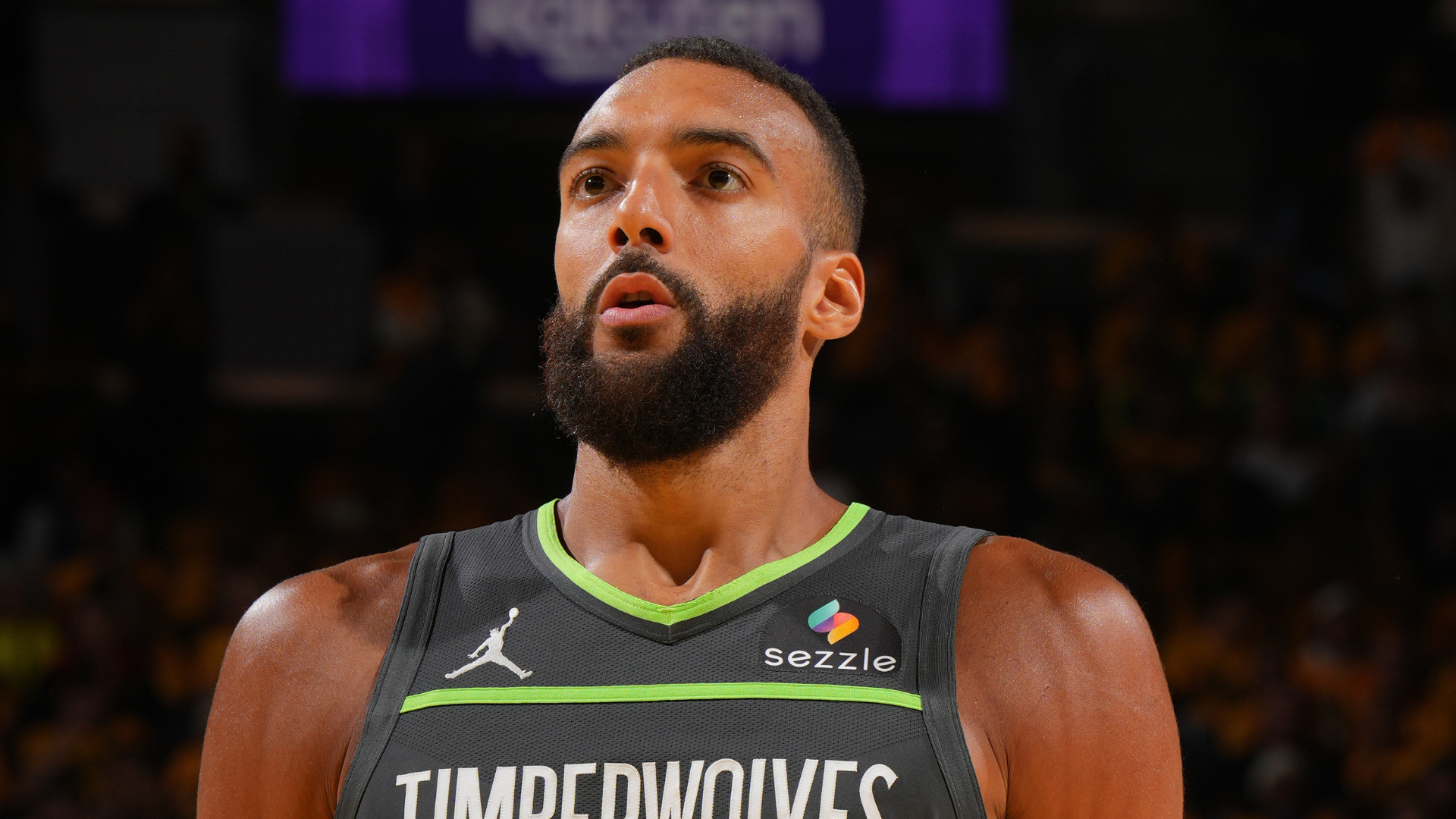 A basketball player in a Timberwolves jersey, focused during a game.