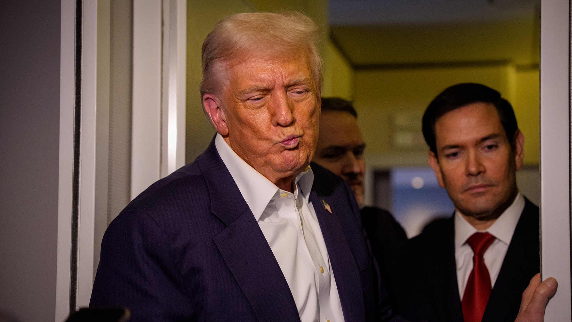 President Donald Trump, accompanied by U.S. Secretary of State Marco Rubio (R), takes a question from a reporter aboard Air Force One on October 27, 2025, in flight.