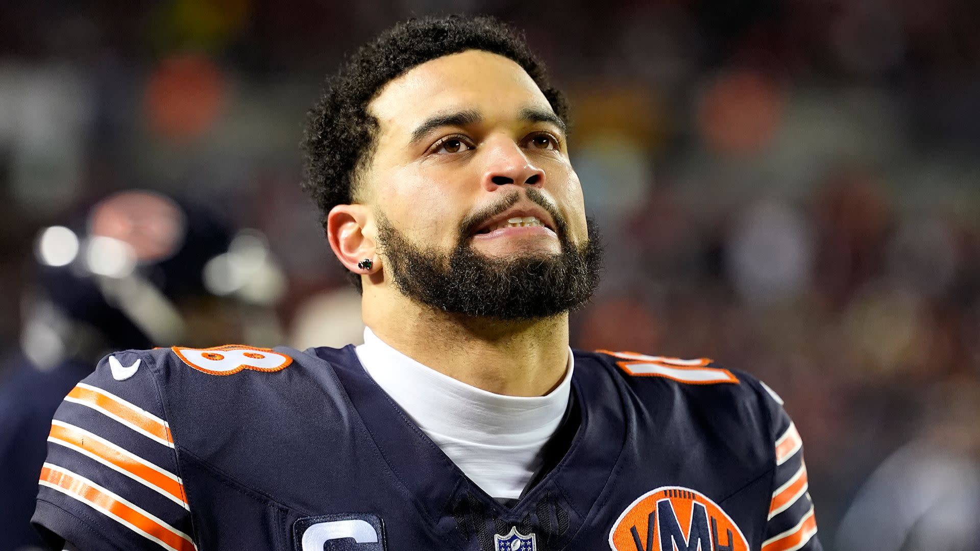 A football player in a Chicago Bears uniform looking up, with a focused expression.