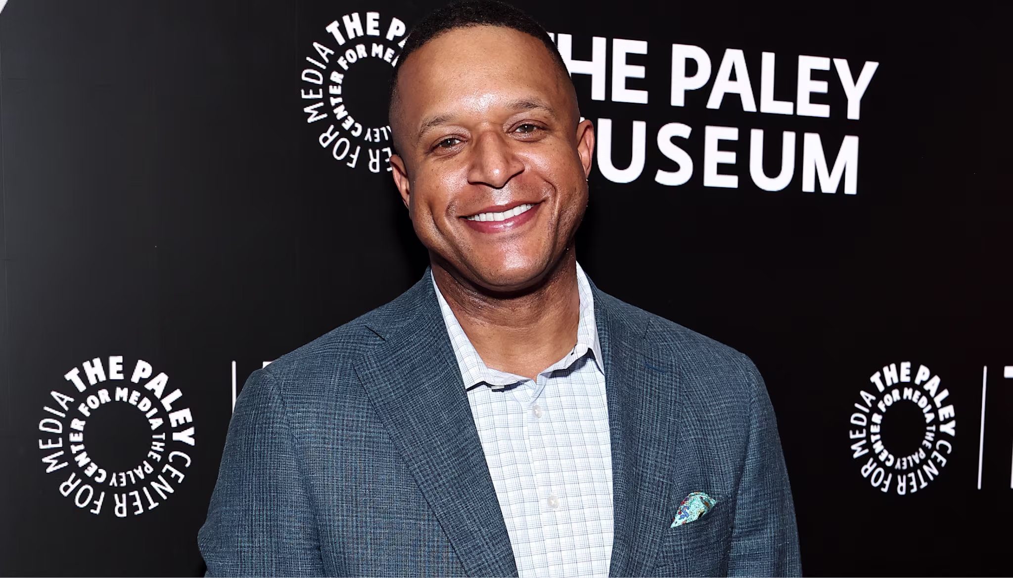A person in a blue blazer smiles at an event with "The Paley Museum" logo in the background.