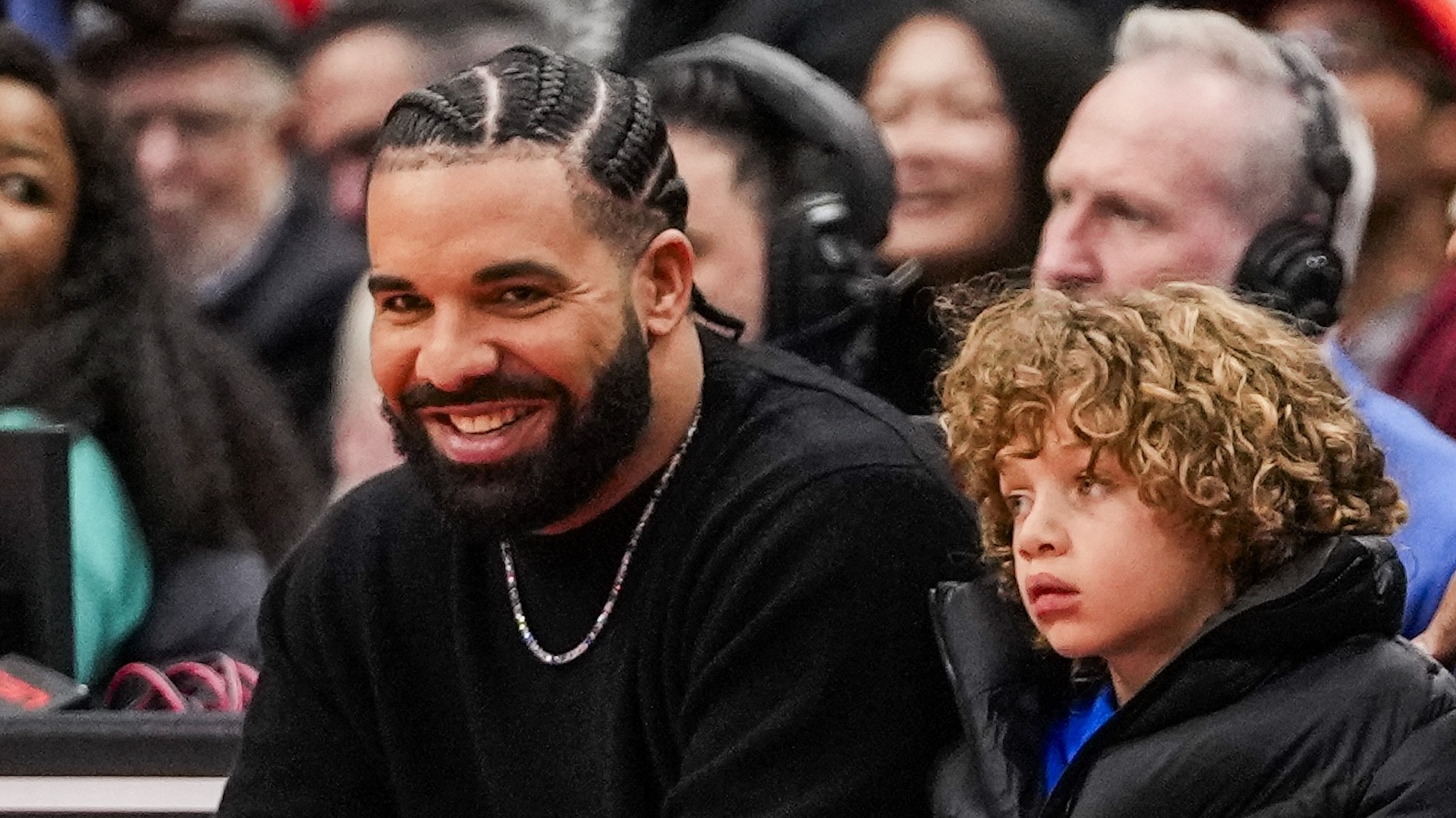 Drake and Adonis watch as the Toronto Raptors host the Phoenix Suns during NBA action at the Scotiabank Arena on November 29, 2023 in Toronto, Ontario, Canada.