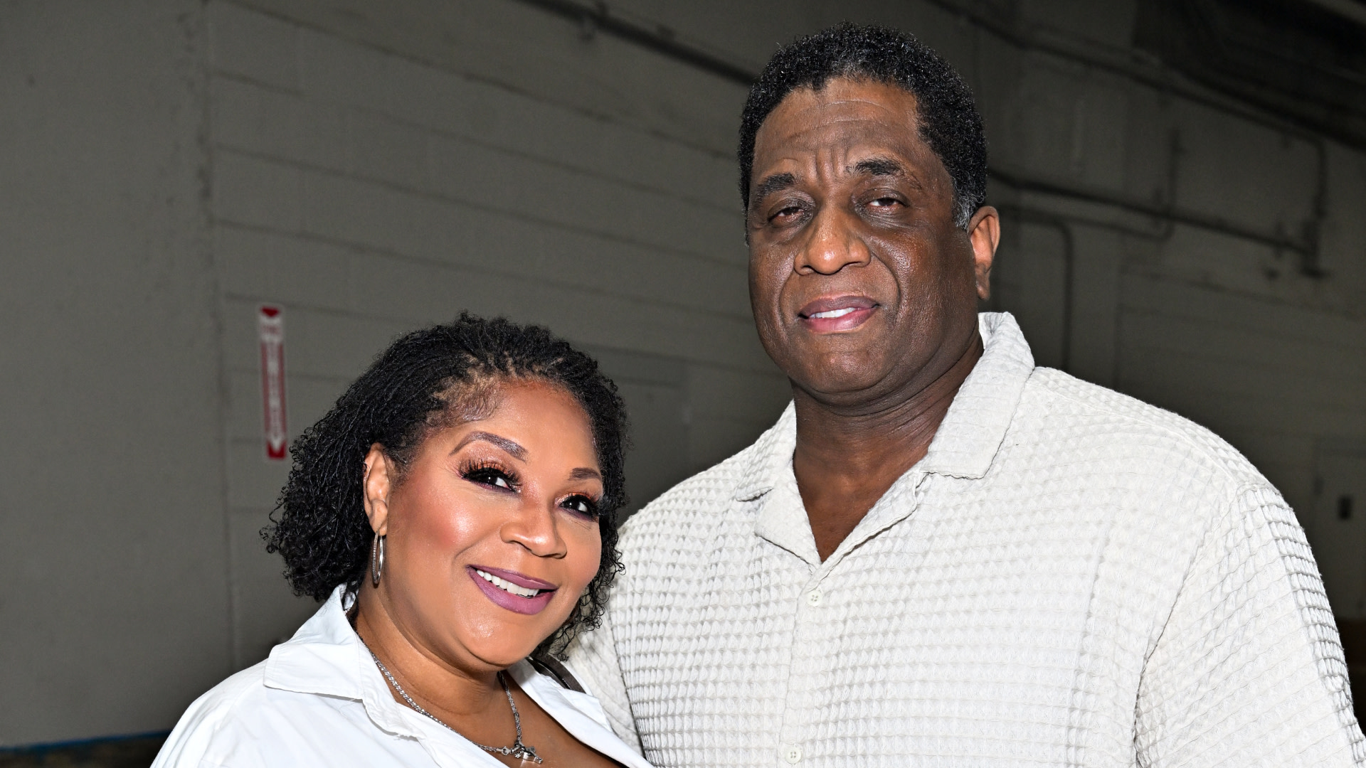 Trina Braxton and Von Scales pose indoors, both wearing light-colored tops. The background is a plain wall.