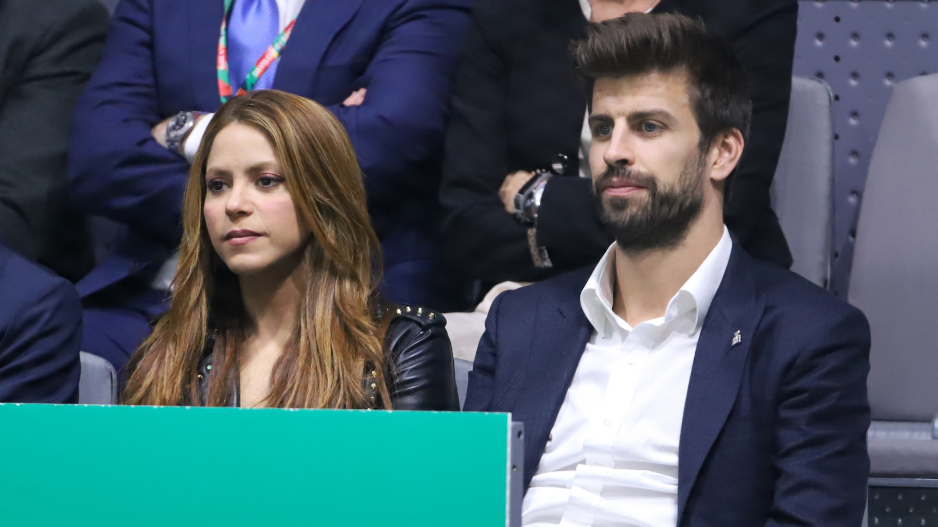 Shakira and Gerard Piqué sitting together at an event, both looking focused.