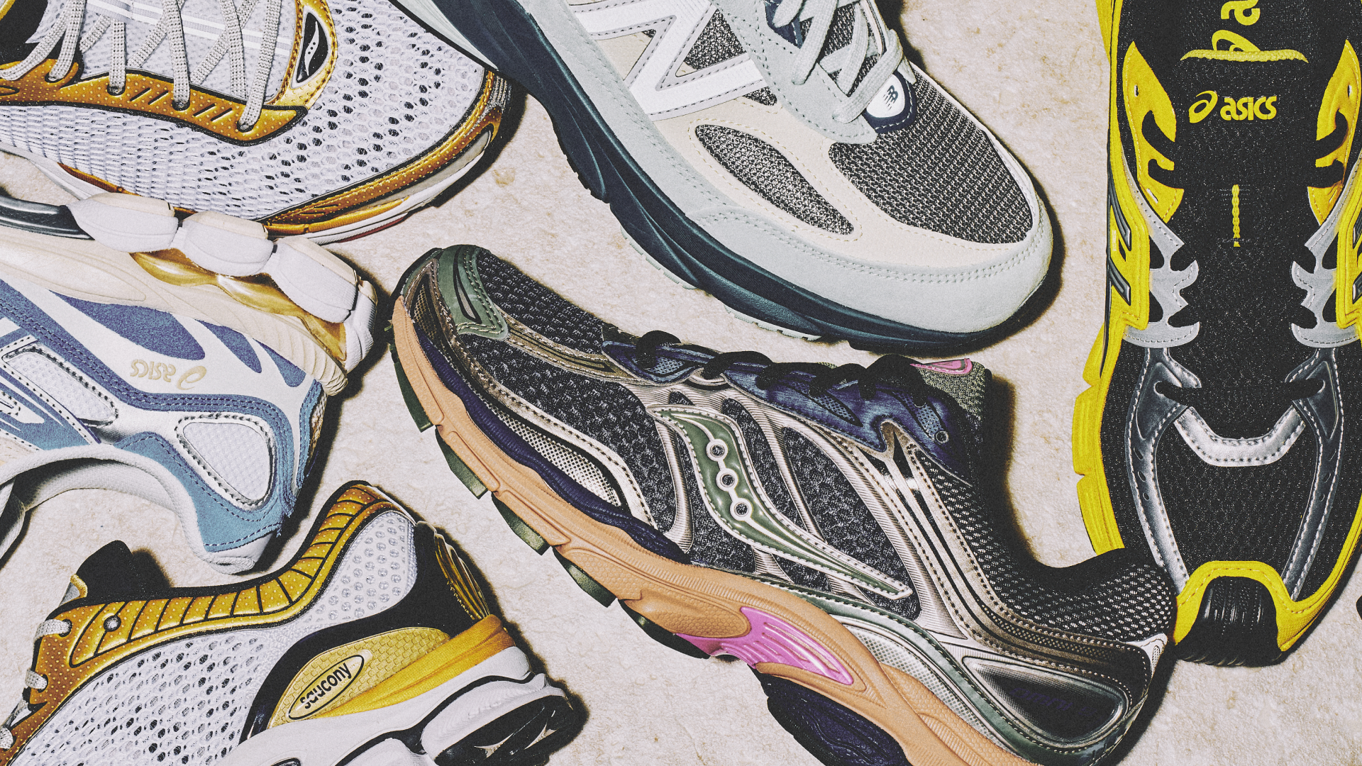 A variety of colorful running shoes from brands like New Balance, Asics, and Saucony are arranged on a light surface.