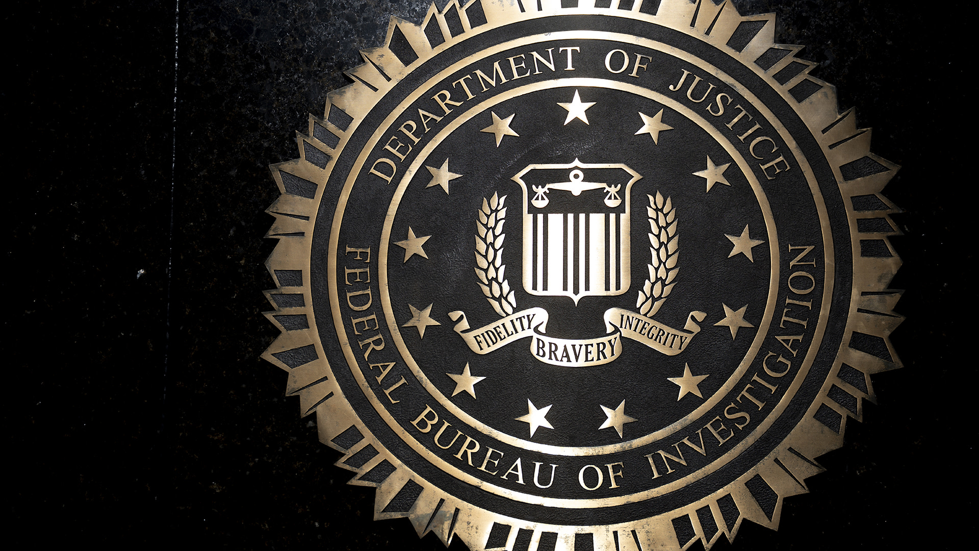 The image shows the seal of the Federal Bureau of Investigation (FBI) with the words "Department of Justice" and "Fidelity Bravery Integrity."
