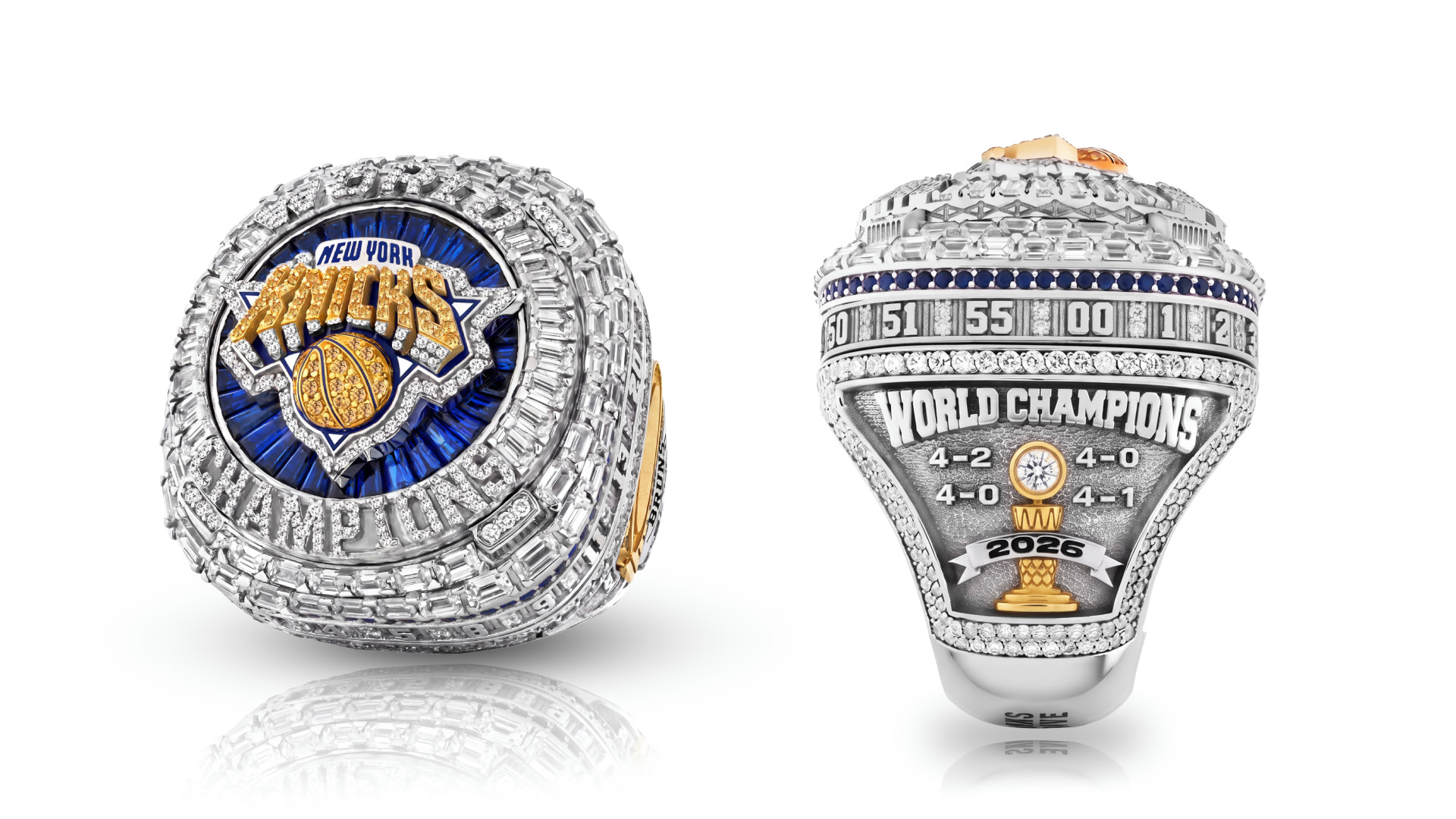 Two New York Knicks championship rings, adorned with diamonds and team logo, displaying "World Champions" and "2026" with scores.