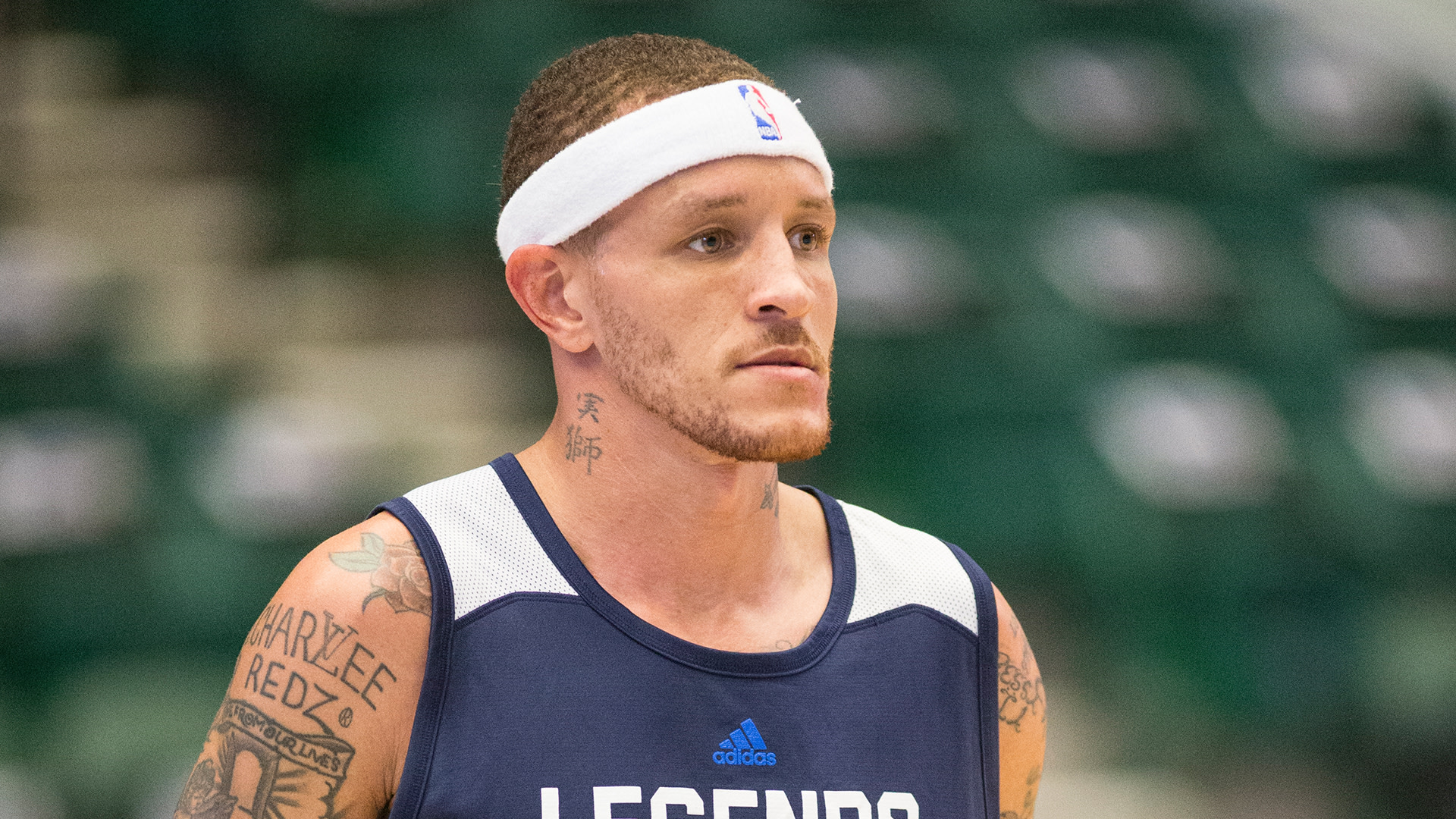 Delonte West wearing a headband and a "Legends" jersey, standing in a gymnasium.