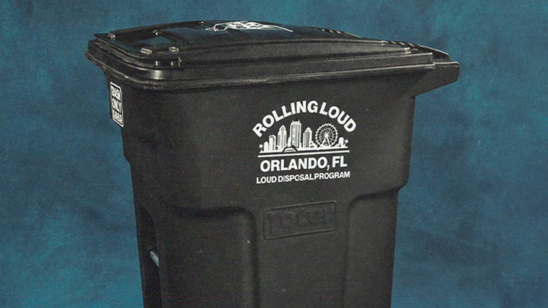 A black trash bin with "Rolling Loud Orlando, FL Loud Disposal Program" printed on it against a blue background.