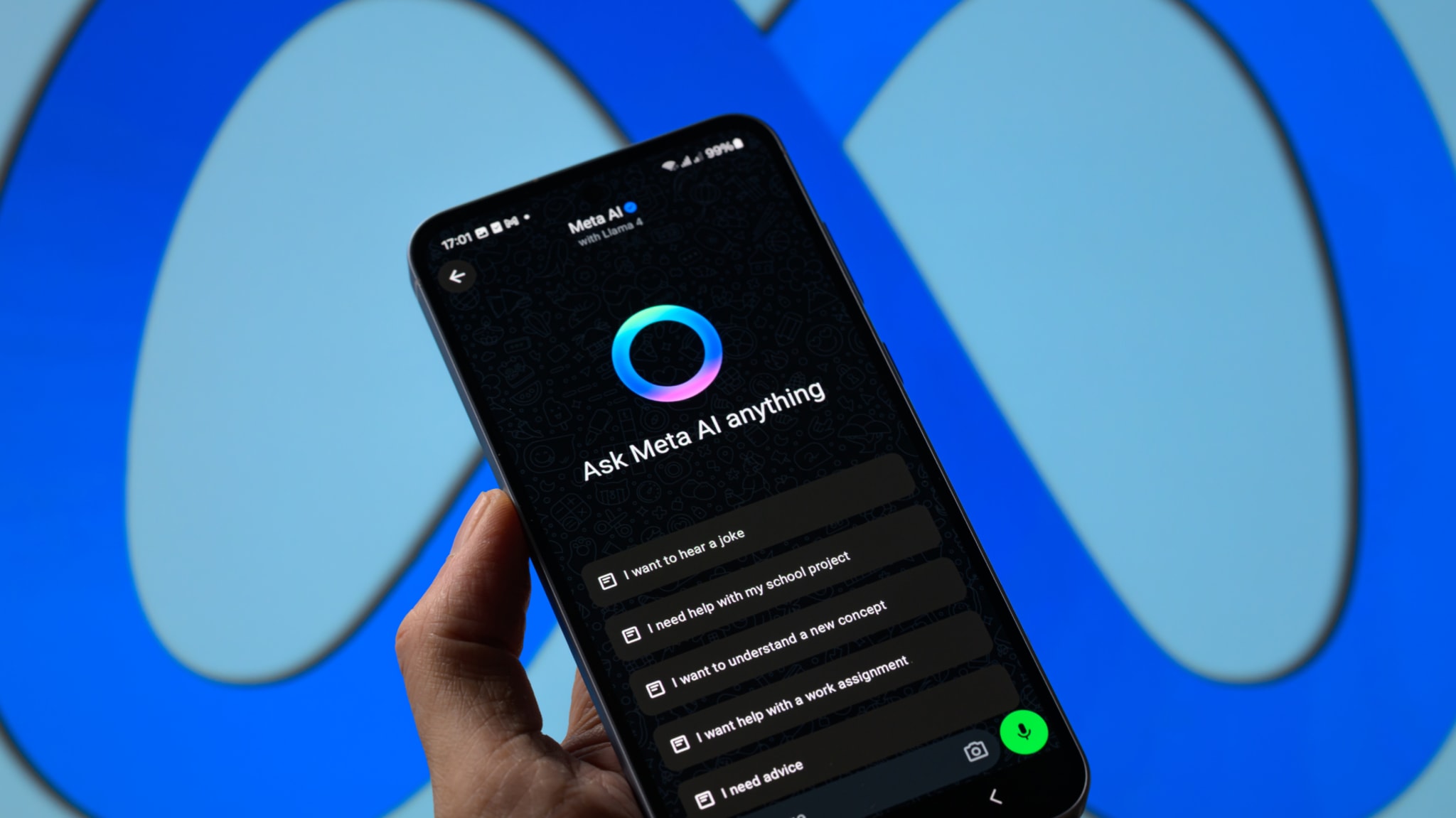 A hand holding a smartphone displaying the "Ask Meta AI anything" interface, with the Meta logo in the background.