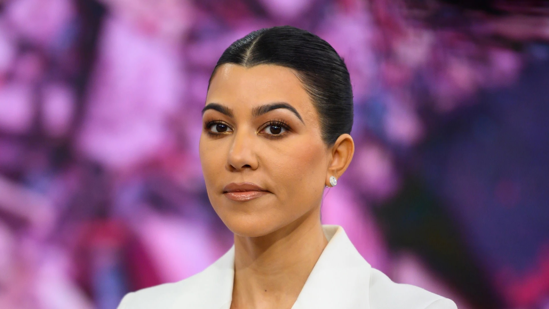 Kourtney Kardashian made a press appearance with sleek hair and a white outfit.