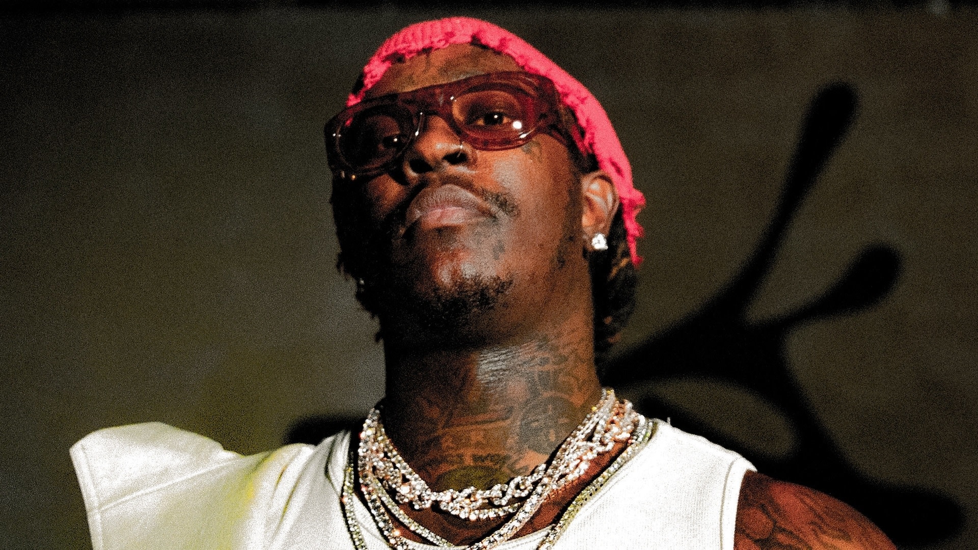 Young Thug in a white tank top with chains and sunglasses