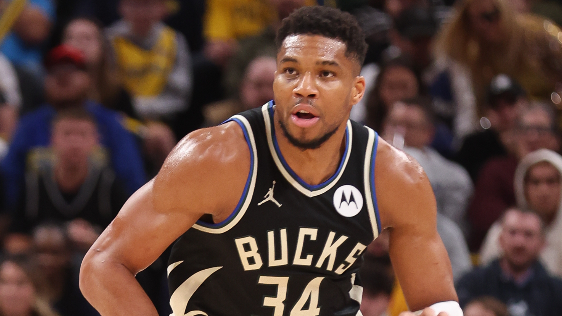 Basketball player in a Milwaukee Bucks jersey, number 34, playing in a game.