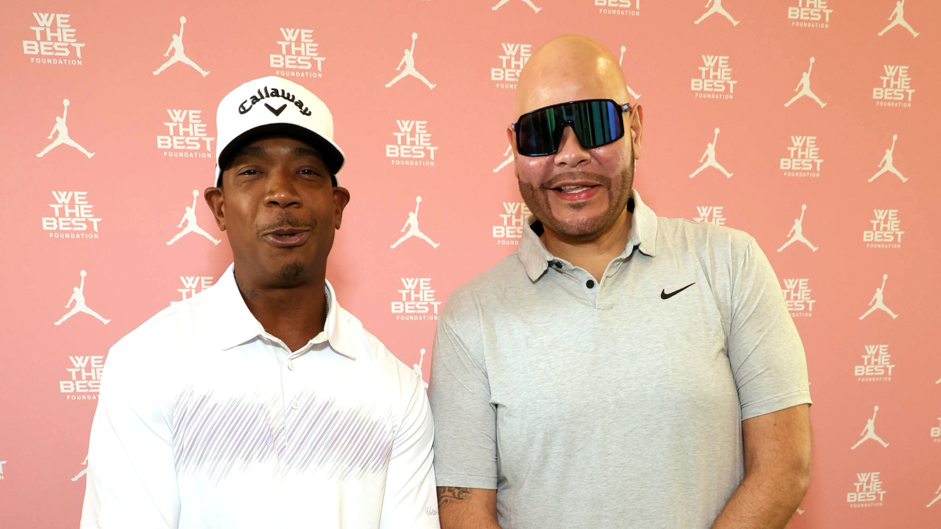 Ja Rule and Fat Joe posing in front of a "We The Best" Foundation backdrop, both smiling.
