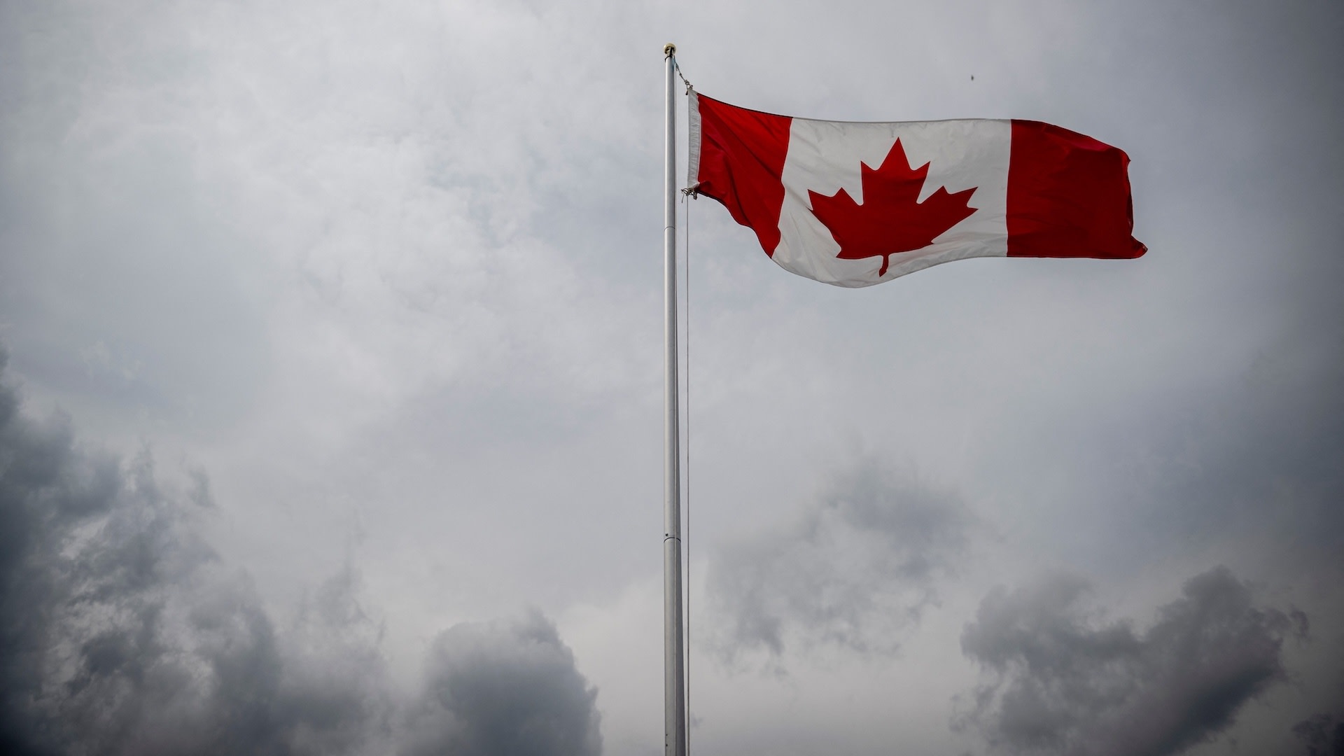A Canadian flag flies during the Canada Day Celebrations in the Old Port in Montreal, Quebec, on July 1, 2025.s All About Family at Montreal's Old Port" in Montreal on July 1, 2025. 