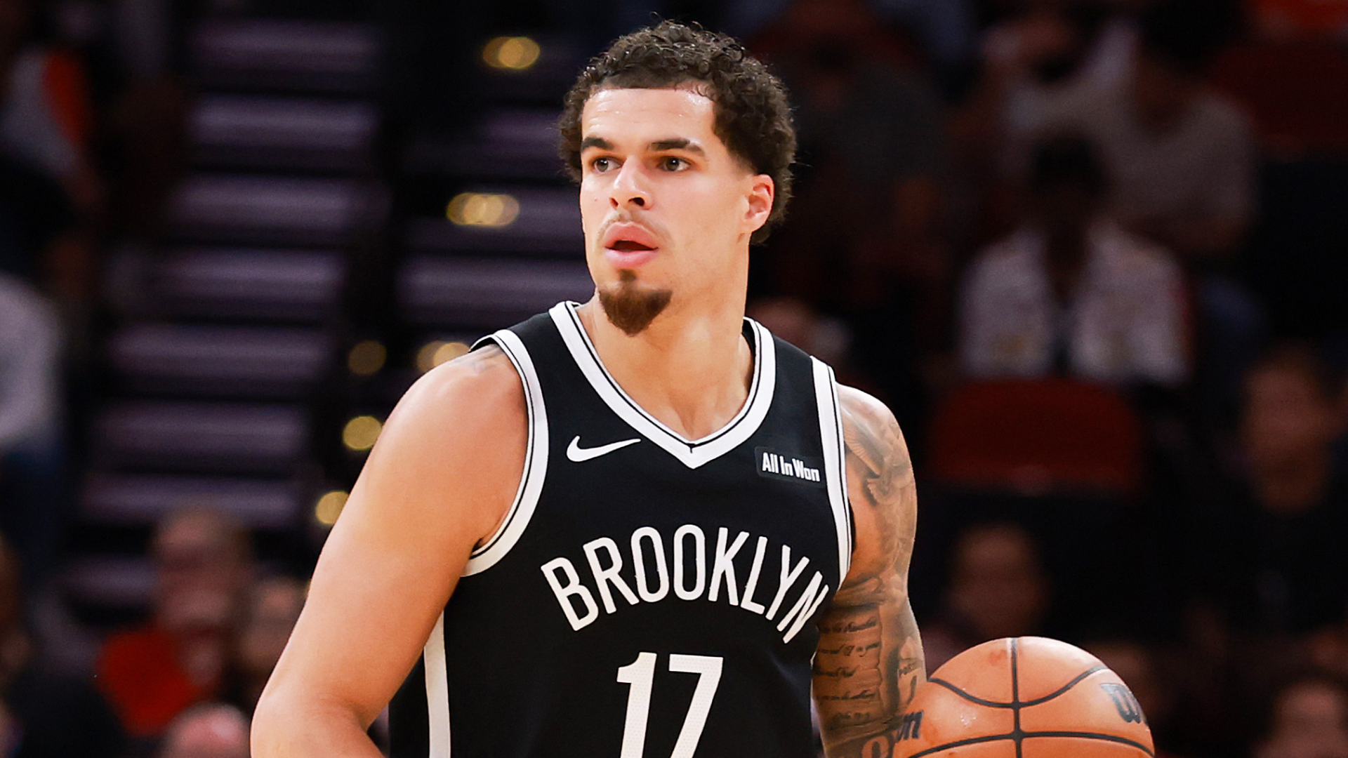 Basketball player in a Brooklyn Nets jersey, number 17, holding a basketball on the court.