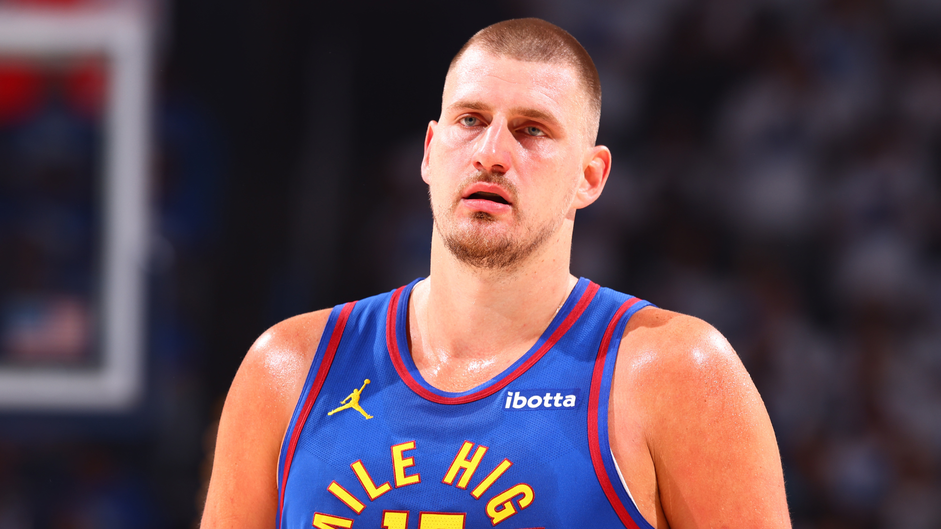 A basketball player in a "Mile High" jersey, looking focused on the court.