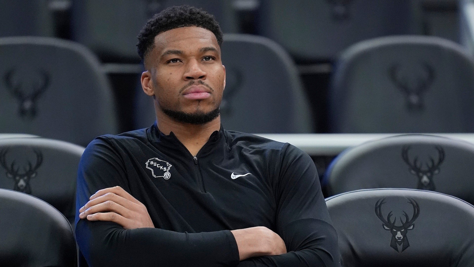 Giannis Antetokounmpo sits by the court before a game against the Brooklyn Nets.