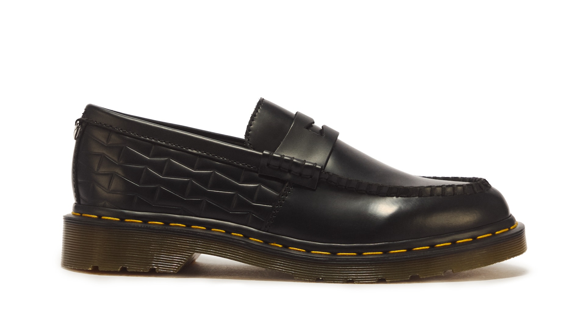 Black leather loafer with textured side pattern and yellow stitching on a chunky sole.
