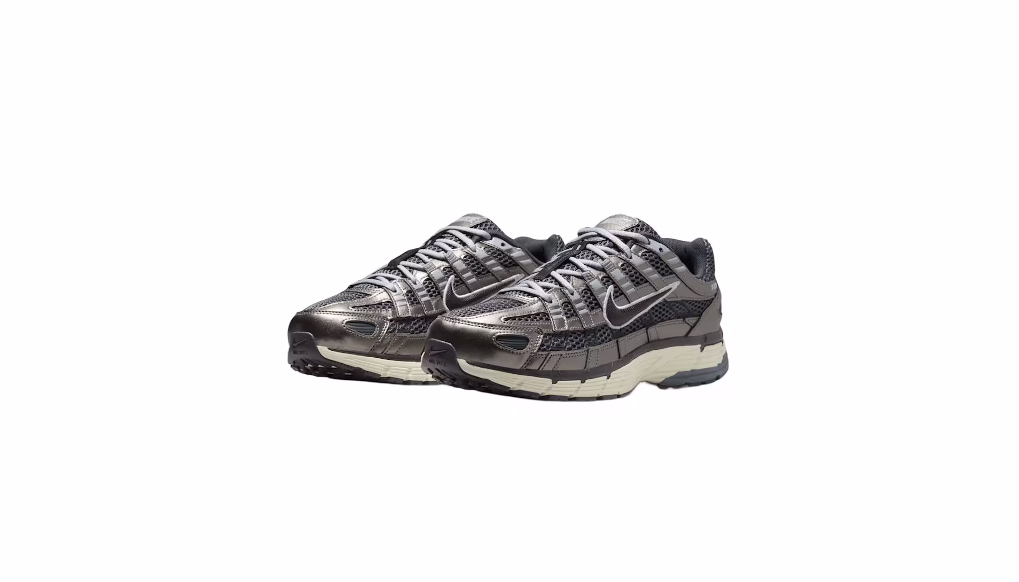 A pair of metallic silver and black Nike sneakers with a beige sole, featuring a mesh design and the iconic Nike swoosh.