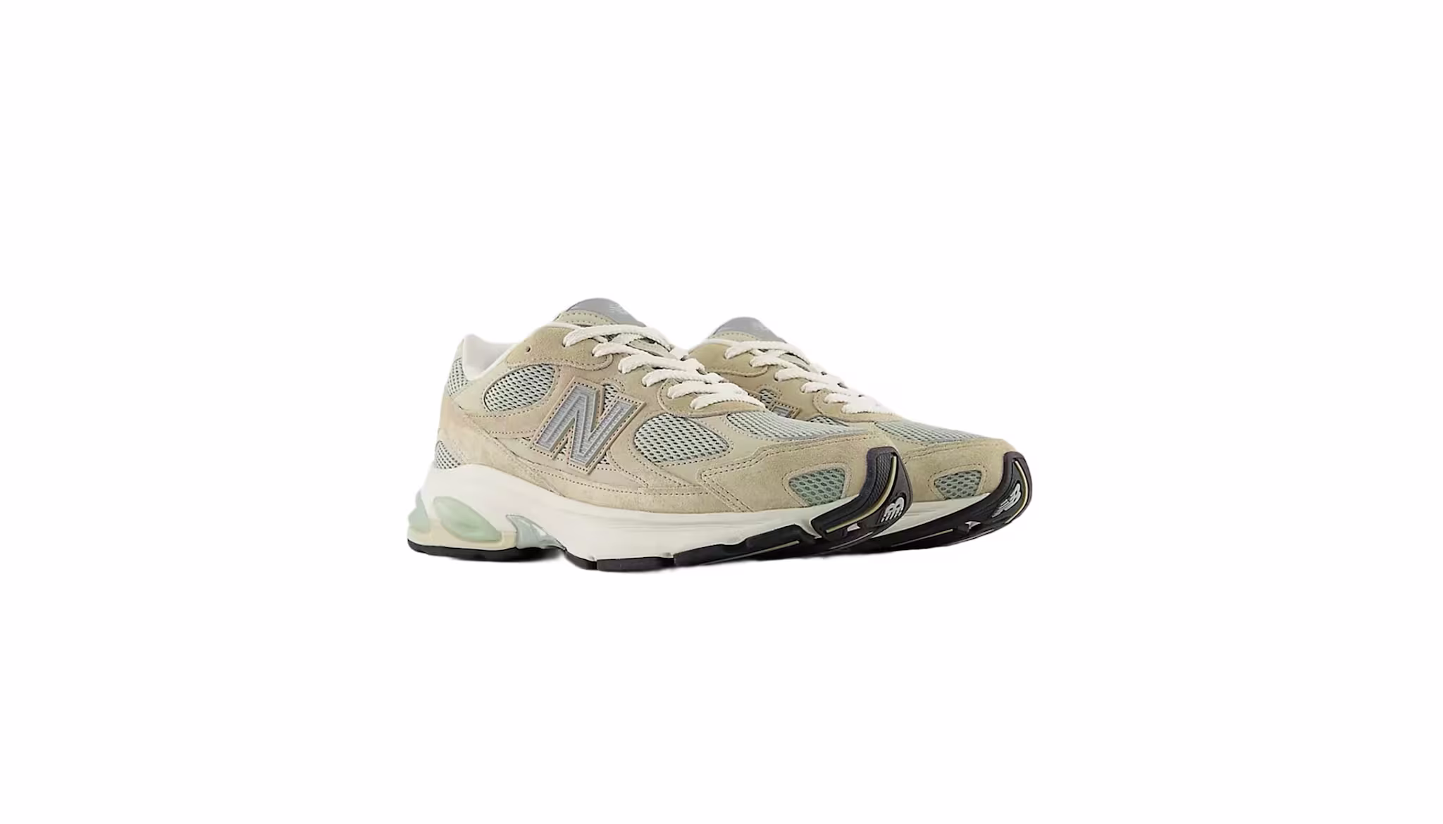 A pair of beige and gray New Balance sneakers with white laces and black soles.