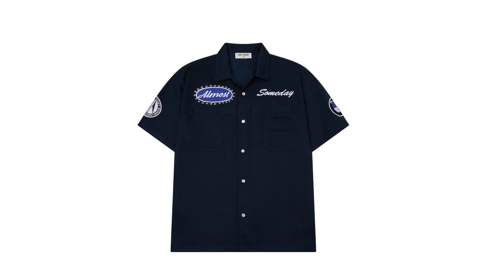 A navy blue button-up shirt with patches reading "Almost" and "Someday" on the front, featuring short sleeves and a collar.