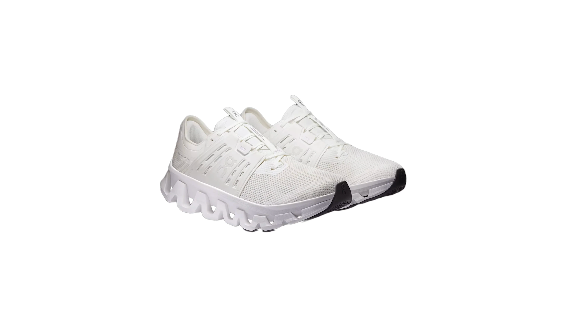 A pair of white athletic sneakers with a unique, wavy sole design and black toe accents.