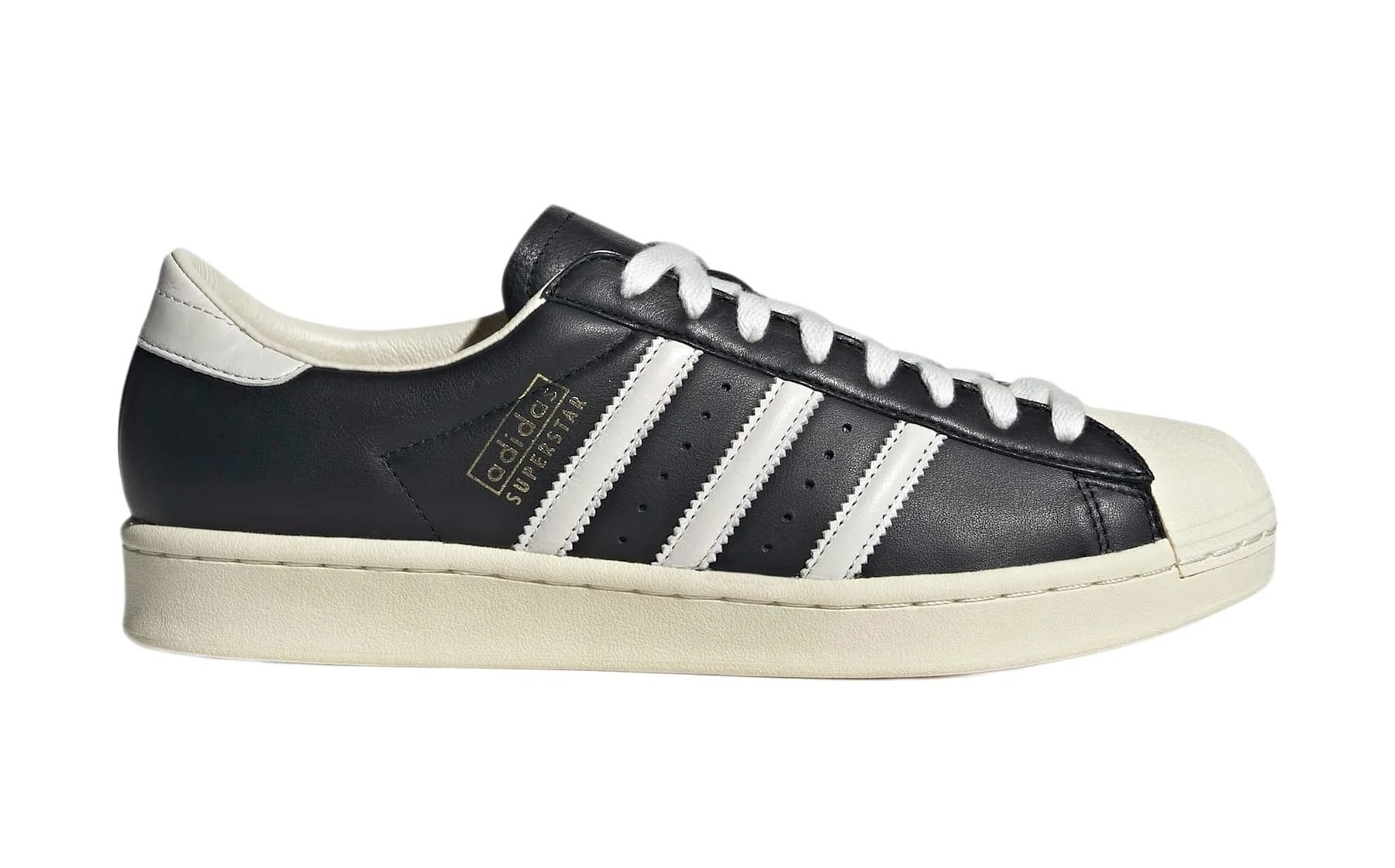 Black Adidas Superstar sneaker with white stripes and shell toe, side view.