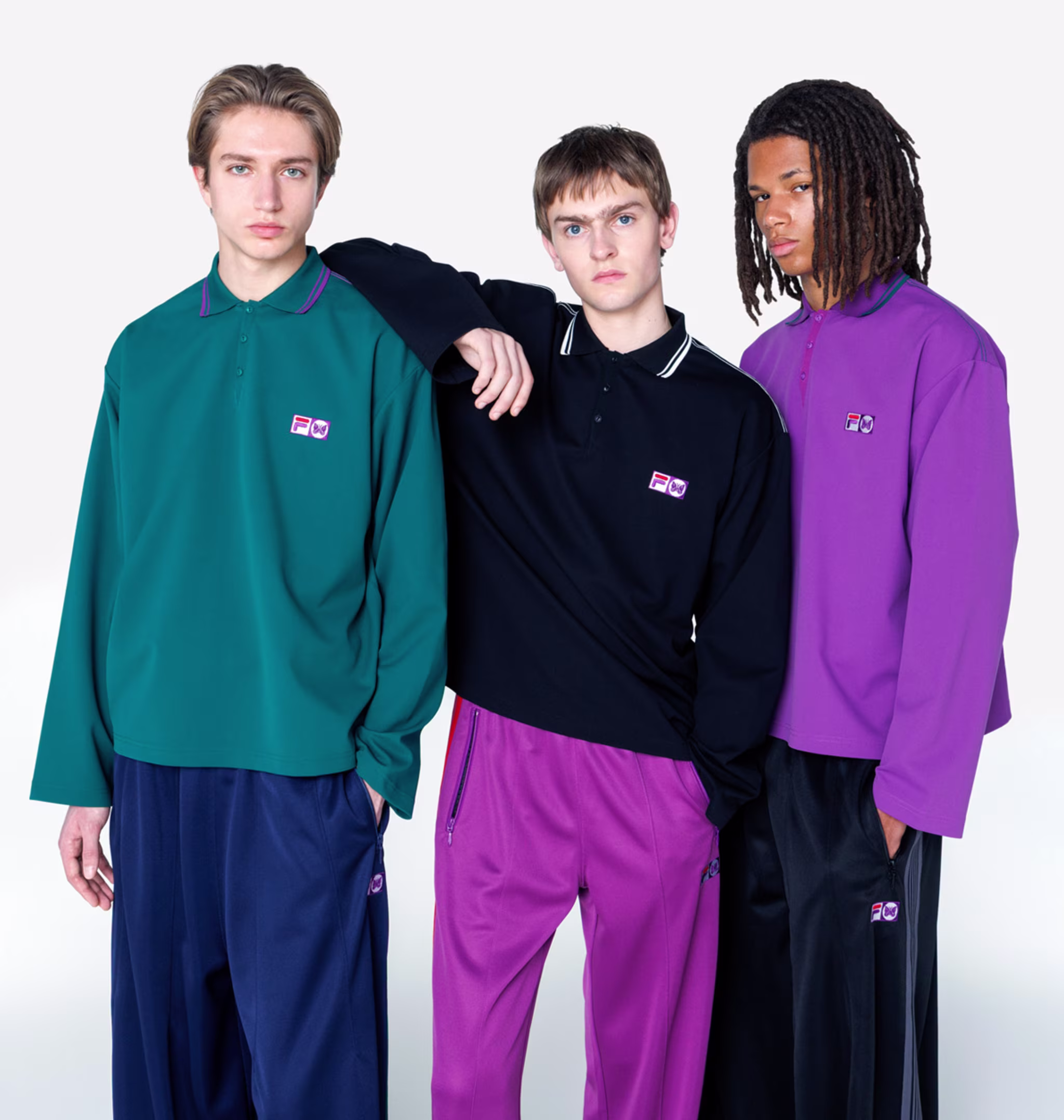 Three models wearing colorful, oversized polo shirts and pants, posing against a plain background.