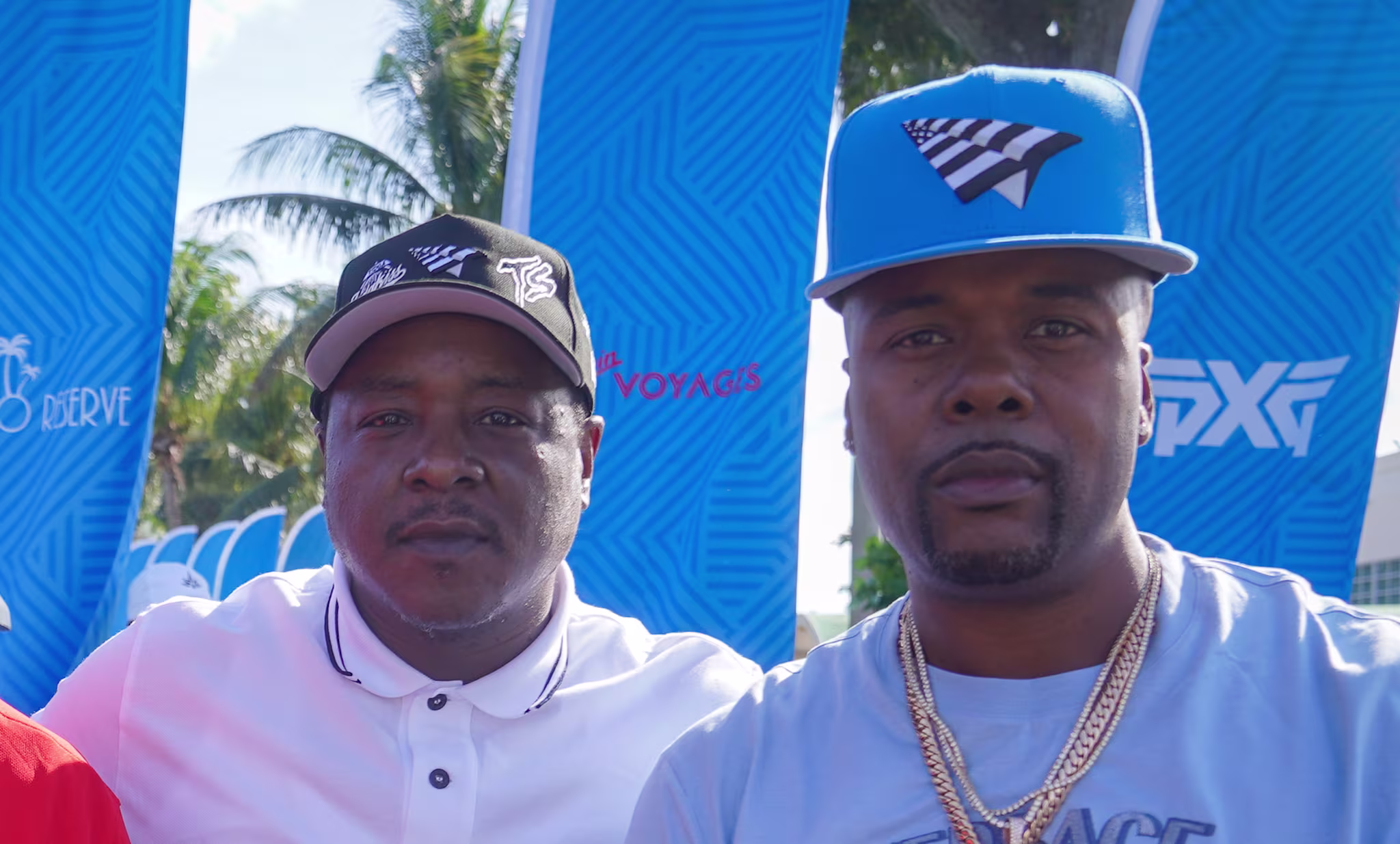 Jadakiss and Memphis Bleek pose together outdoors, smiling and casually dressed.
