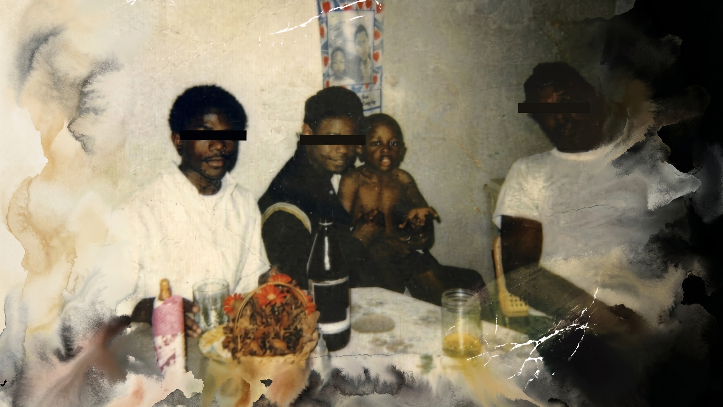 A vintage photograph of four people sitting at a table with food and drinks. The image is worn and partially damaged.