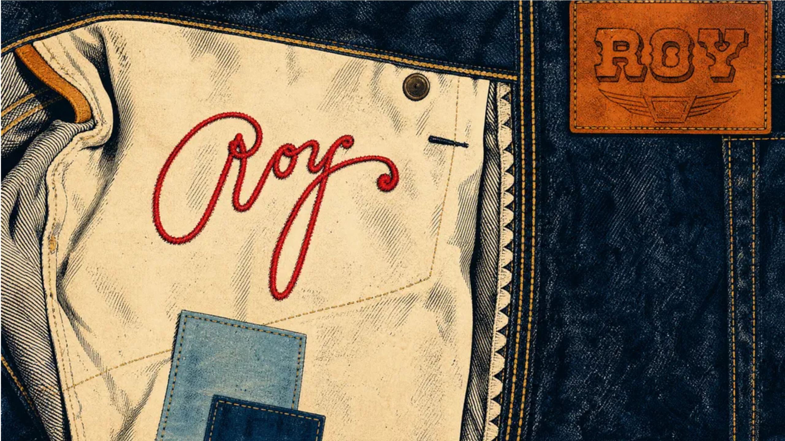 Close-up of denim jeans with "Roy" embroidered in red on the inner pocket and a leather patch with "ROY" on the waistband.