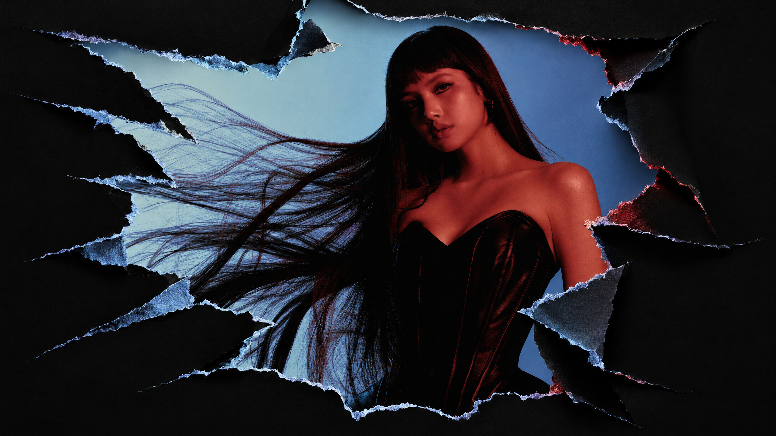 A woman with long hair in a strapless black outfit appears through torn paper with a blue and red gradient background.