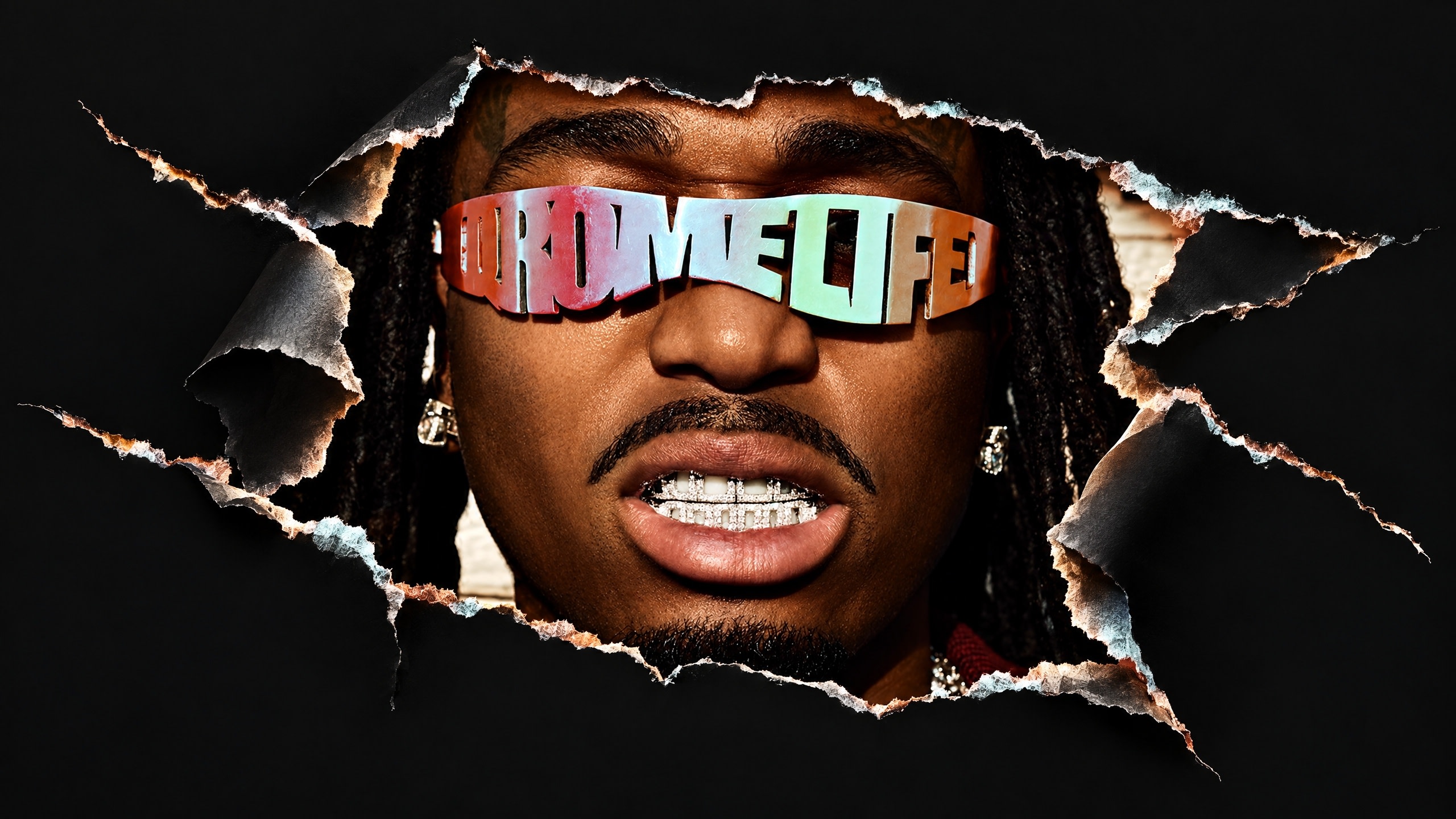 Quavo with sunglasses spelling "HUNCHO" and "LIFE" peers through a torn black background, showcasing diamond grills.