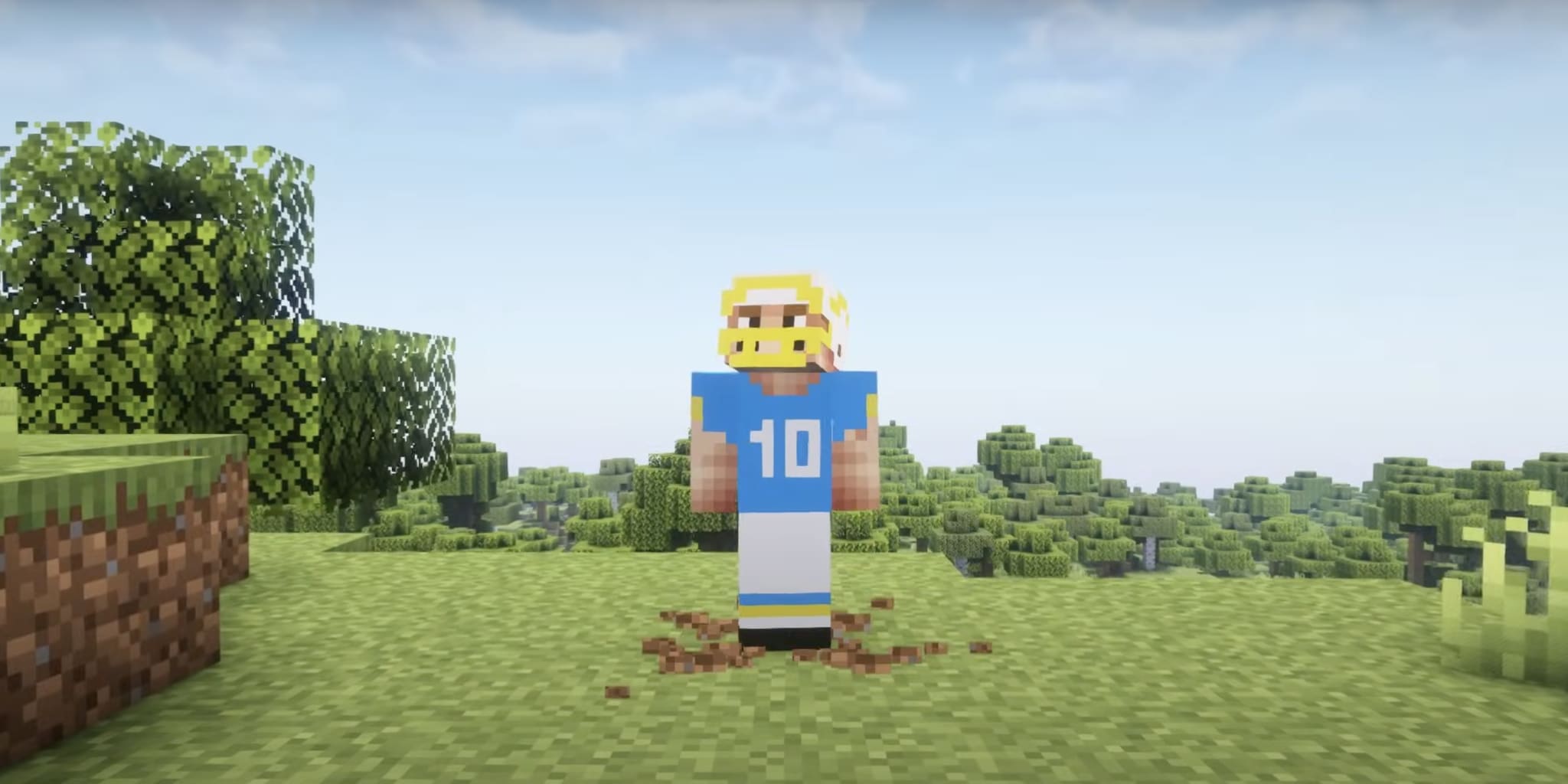 A Minecraft character with blonde hair, wearing a blue jersey with the number 10, stands on grass with trees in the background.