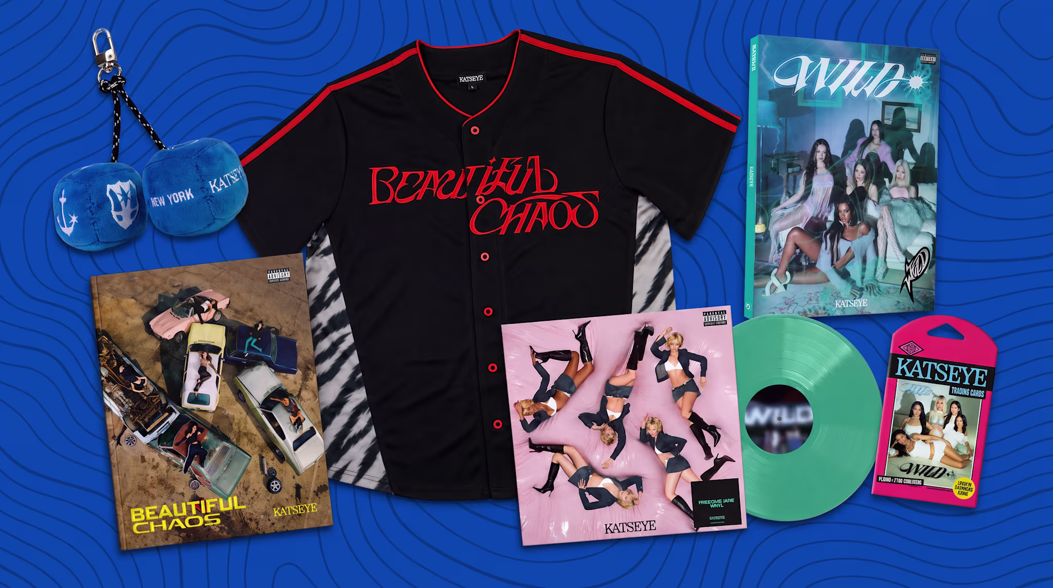 A collection of merchandise including a "Beautiful Chaos" jersey, vinyl records, a keychain, and posters with a blue background.