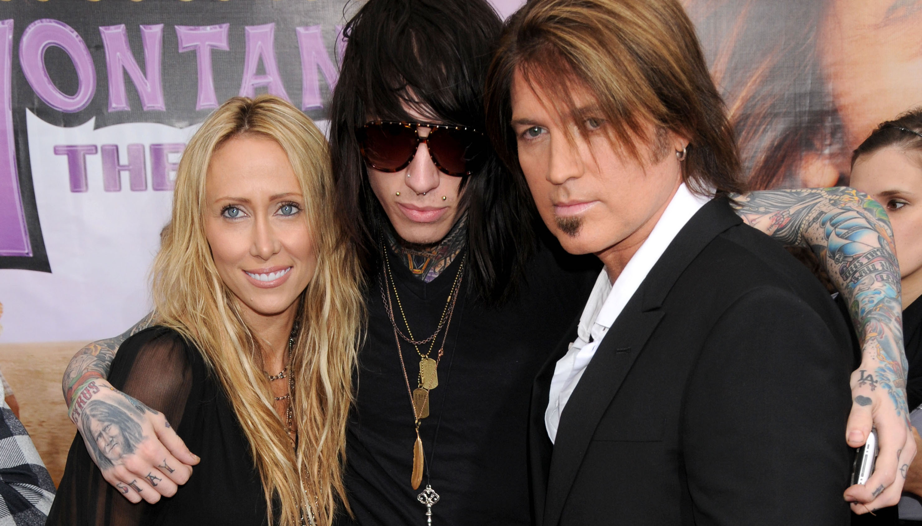 Tish Cyrus, Trace Cyrus, and Billy Ray Cyrus pose together at an event.