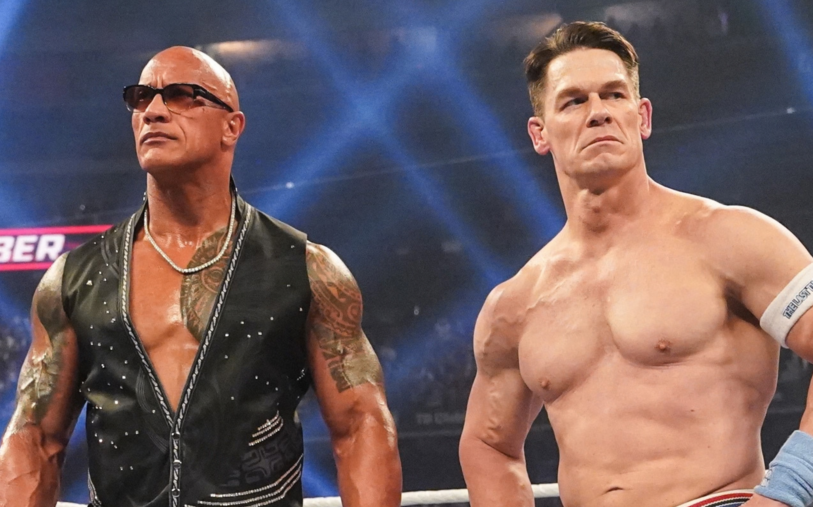Dwayne "The Rock" Johnson and John Cena in a wrestling ring, both looking serious.